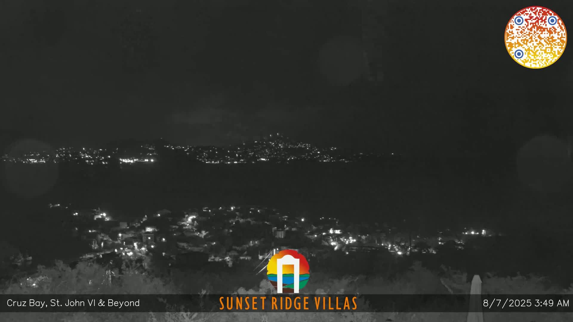 A nighttime long shot shows a town with scattered lights under a dark, clear sky.