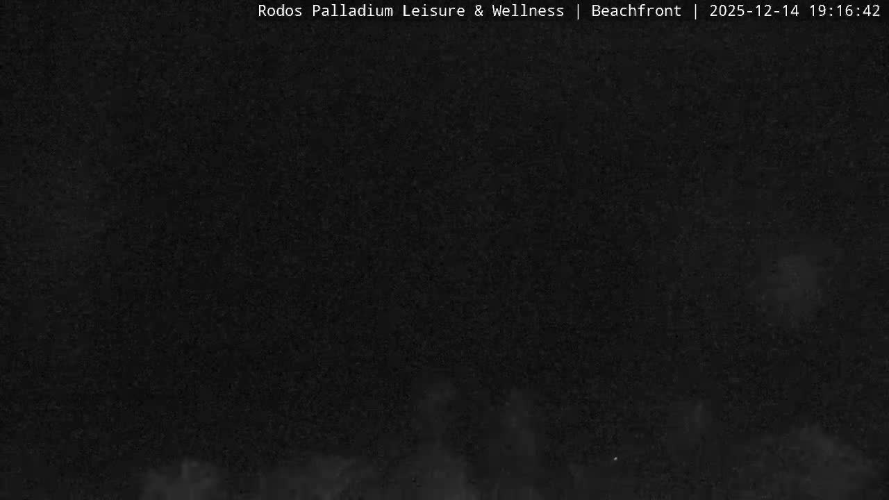 An overcast sky hangs above a broad expanse of muted blue-green ocean water, with subtle white foam visible on its surface.