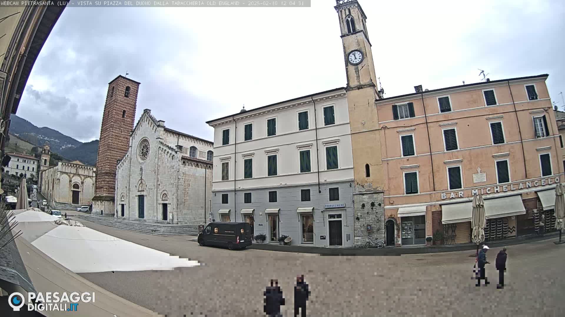 A town square with a church and several buildings, under an overcast sky.