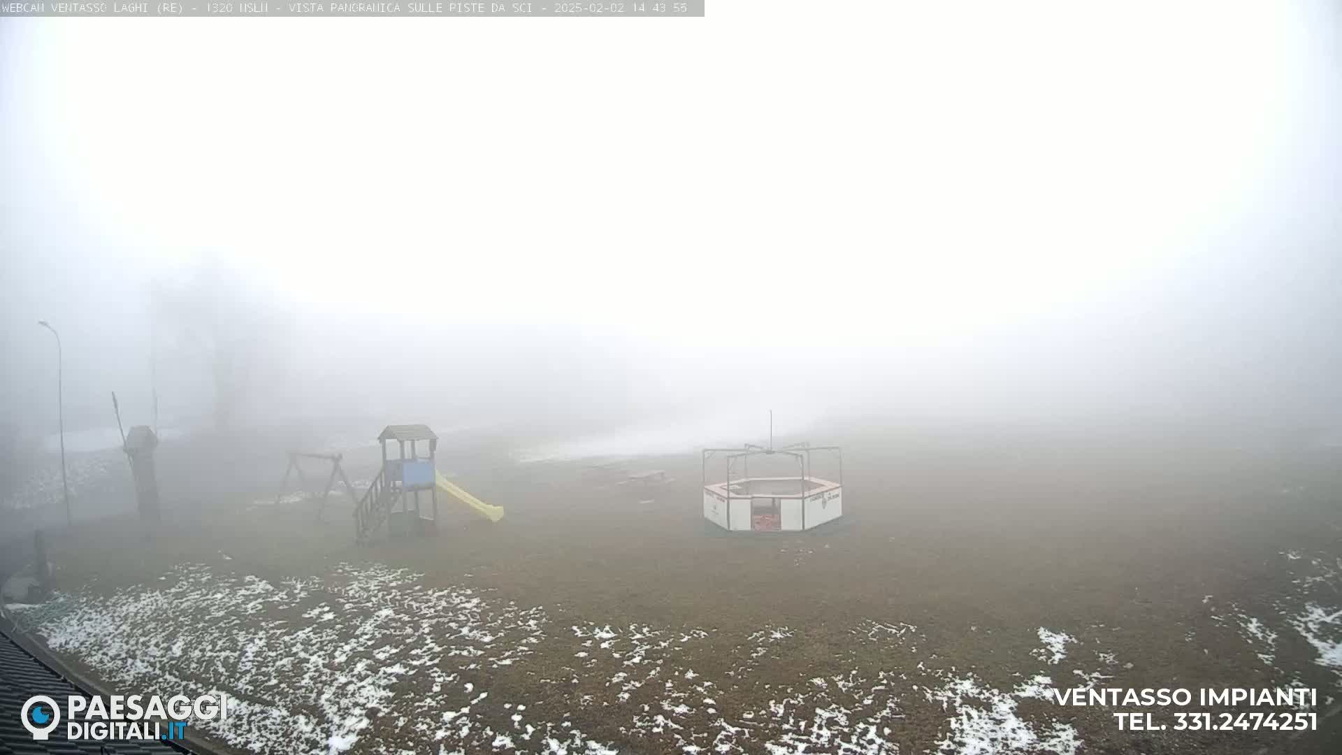 A playground with a slide and other equipment is visible in a foggy, snow-dusted field.