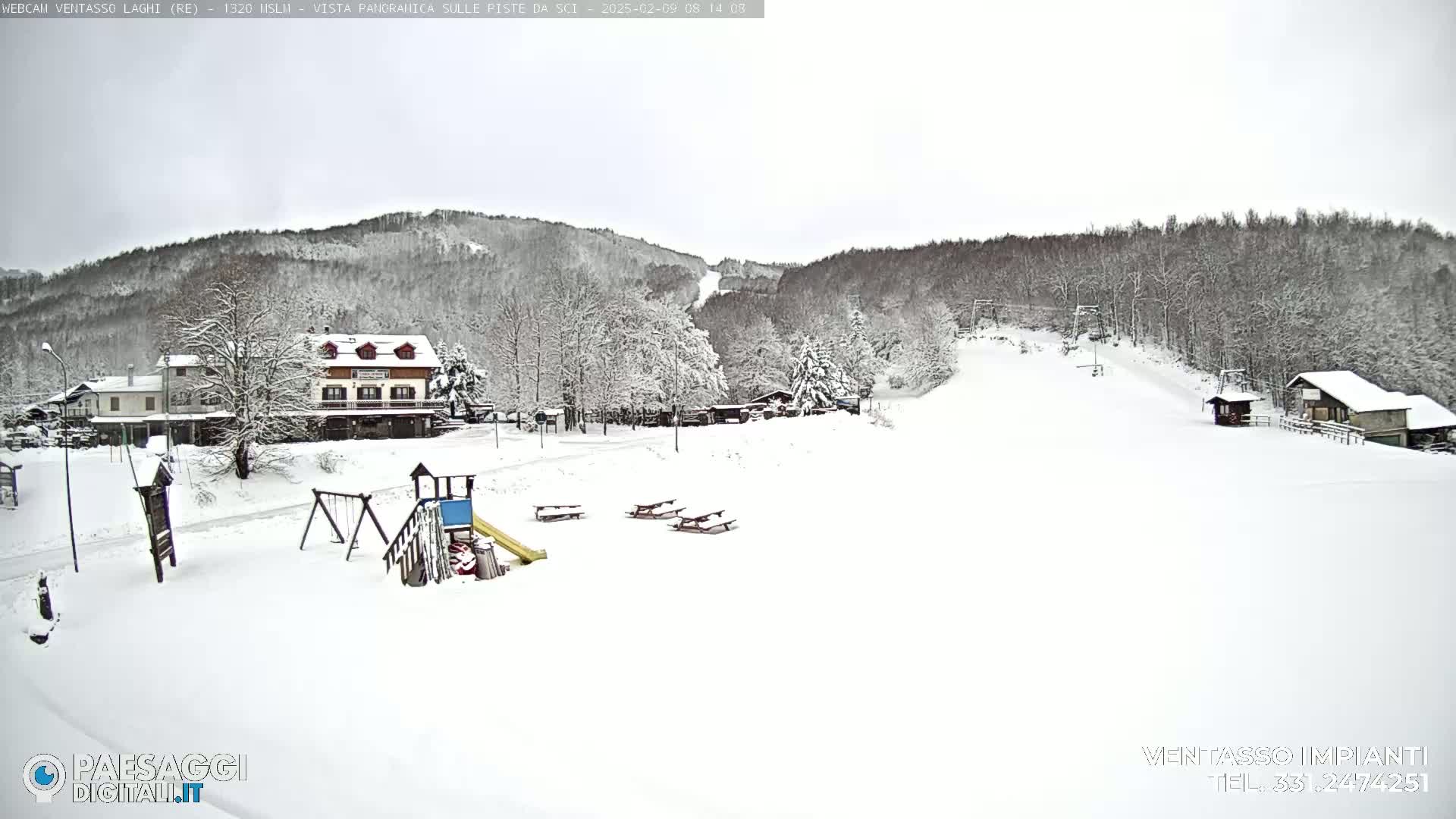 A snow-covered ski slope with buildings, a playground, and picnic tables is visible, under an overcast sky.