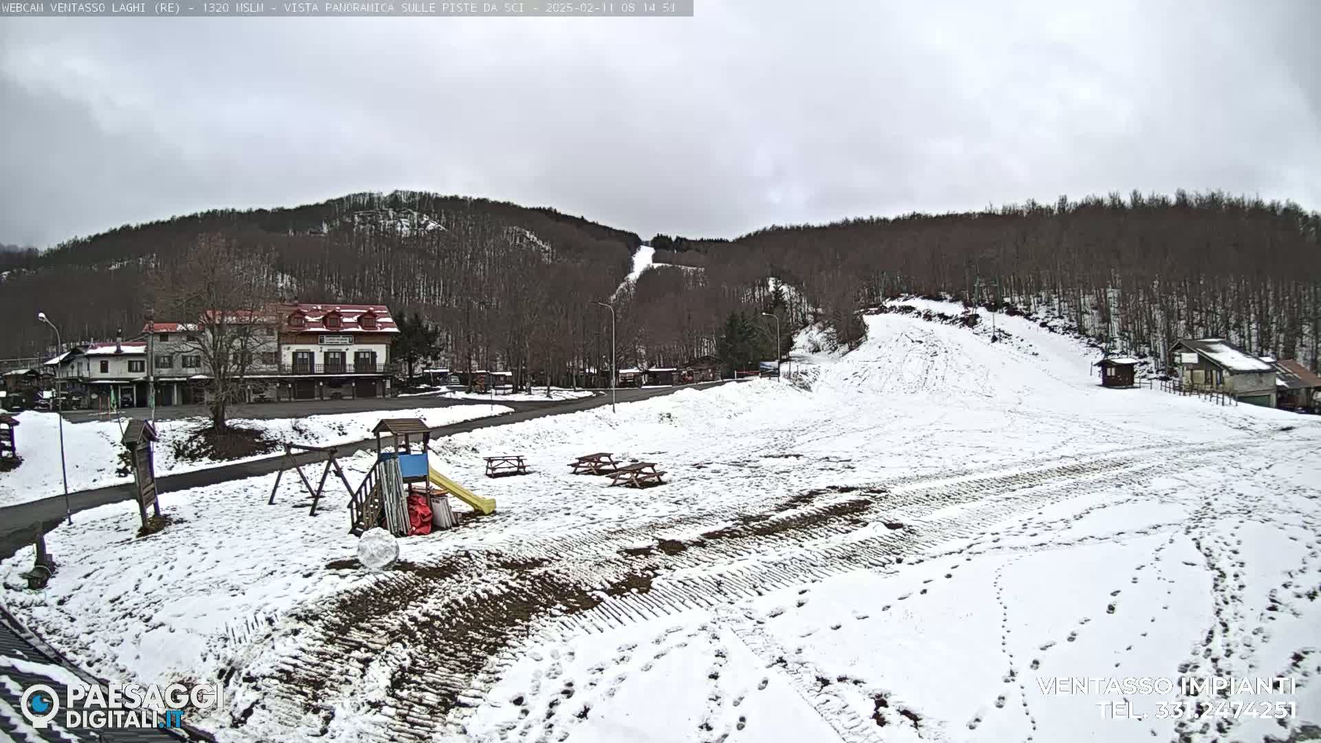 A snow-covered ski slope and village are visible under an overcast sky.