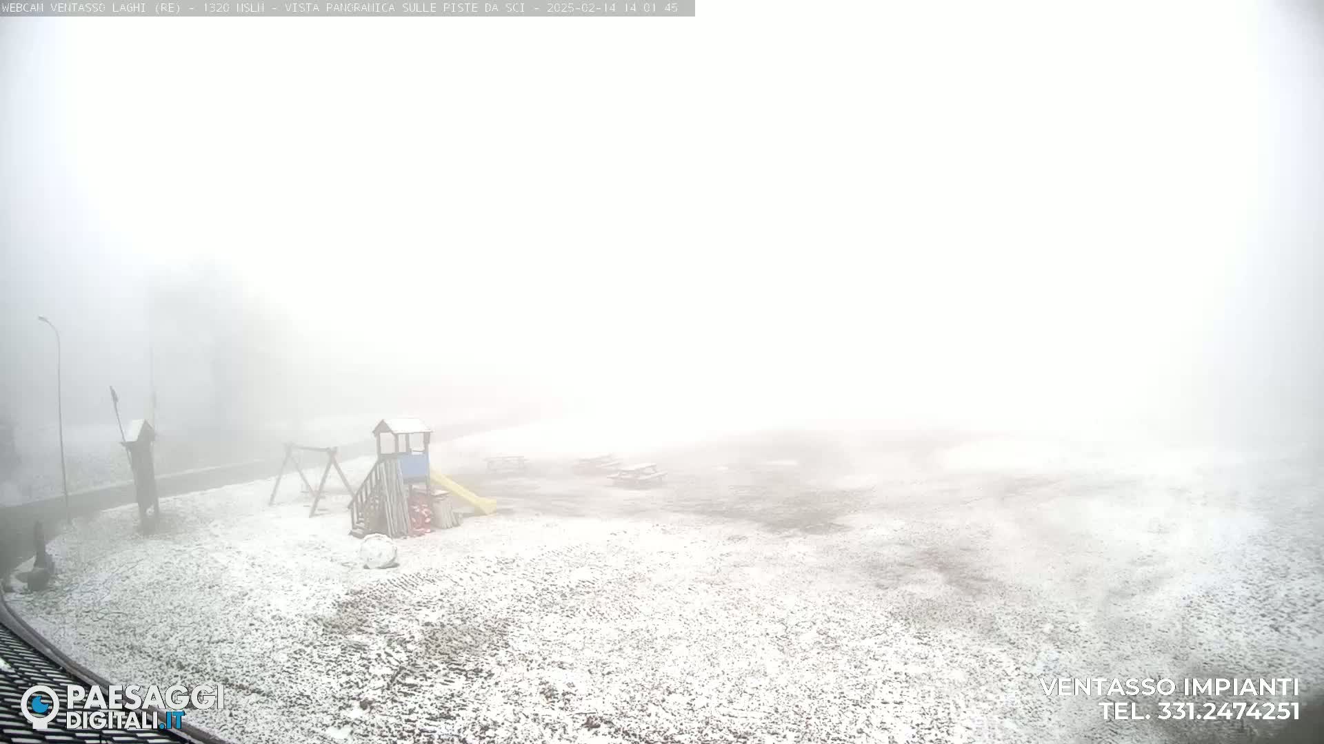A snow-covered playground is barely visible in a thick fog.
