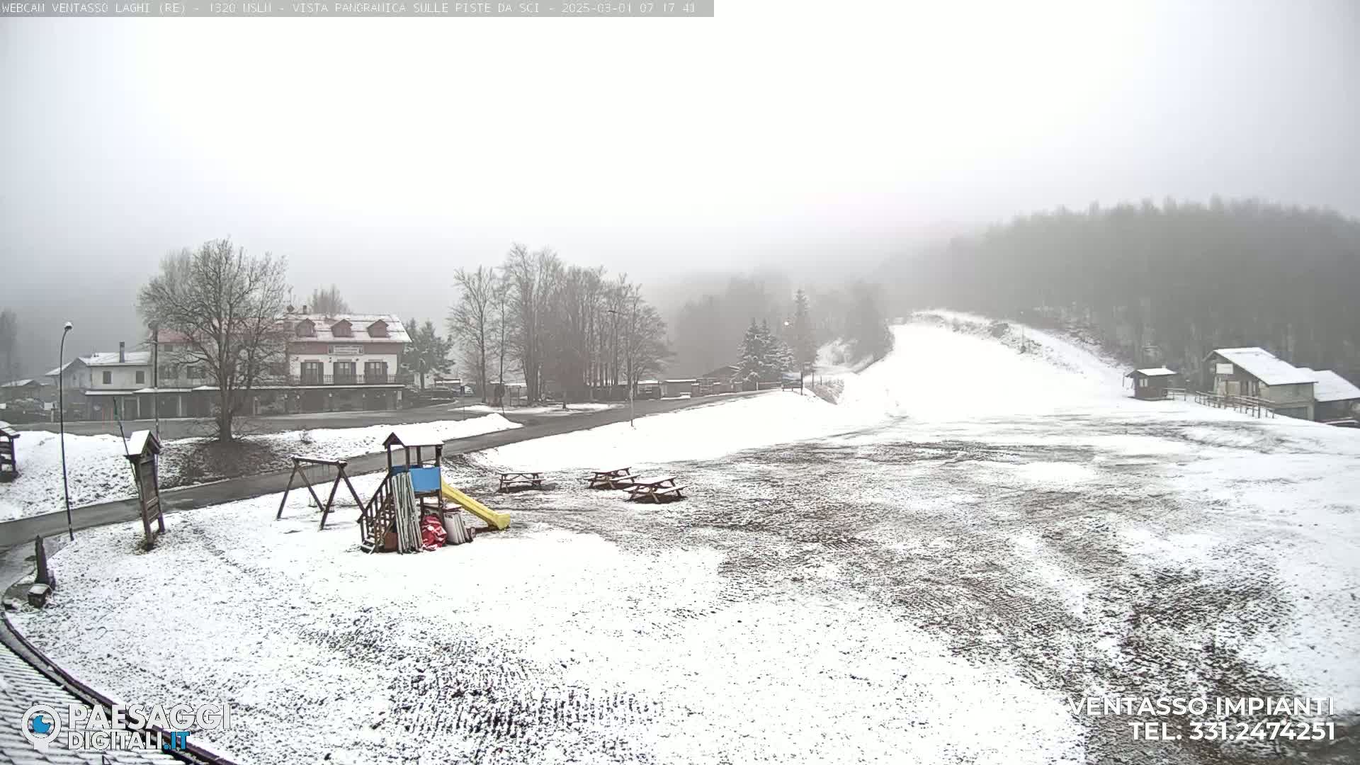 A snow-covered playground and ski slope are visible in a foggy, snowy landscape, with buildings in the background.