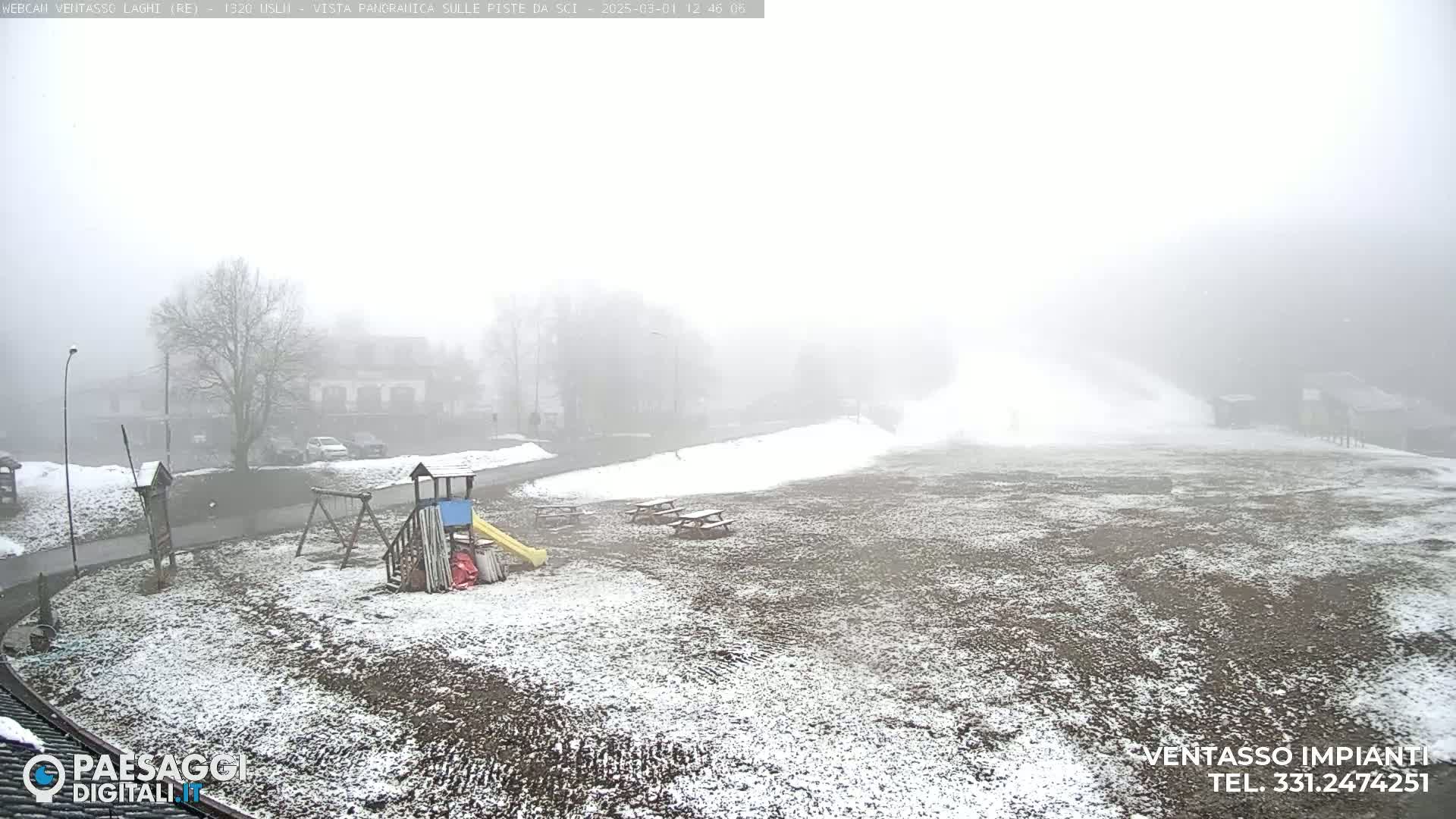 A snow-dusted playground and picnic area are visible in a foggy, snowy landscape.