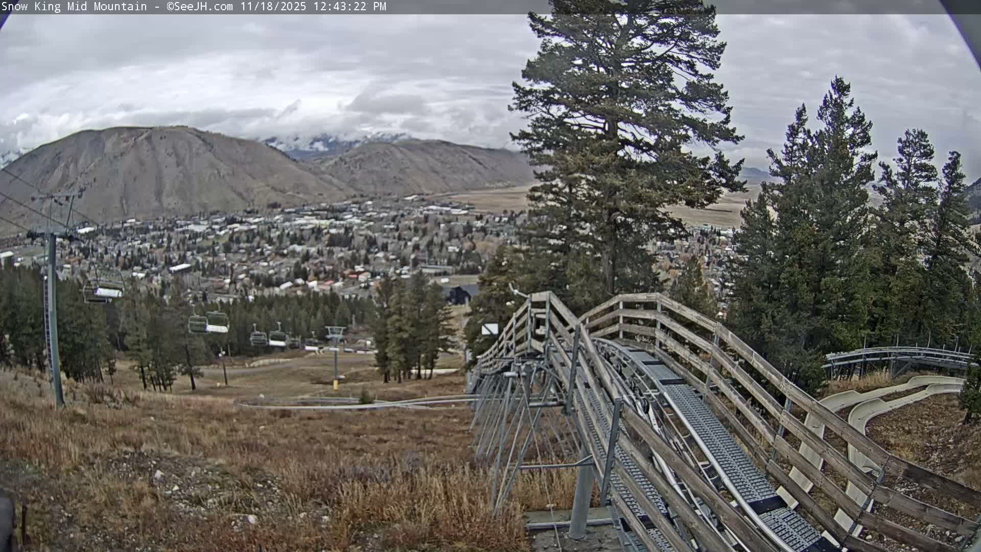 A city or town is seen illuminated by numerous lights at night from an elevated perspective, under clear weather conditions.