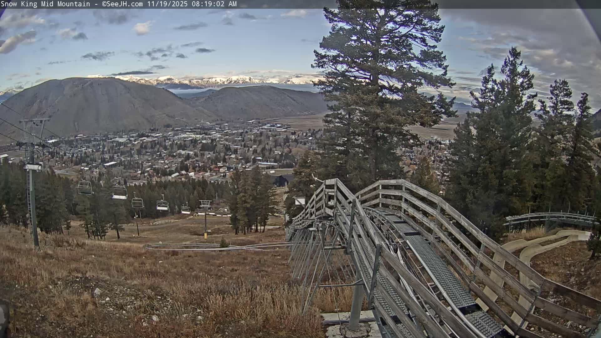 A city or town is seen illuminated by numerous lights at night from an elevated perspective, under clear weather conditions.