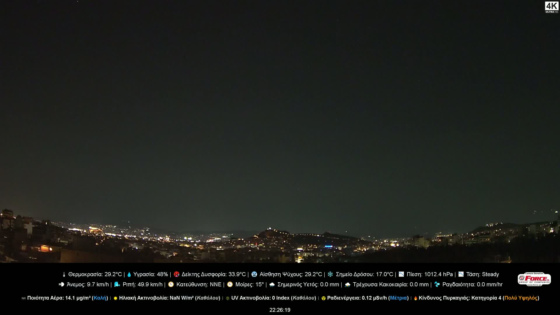 A nighttime view of a city illuminated by lights, under a clear, dark sky.