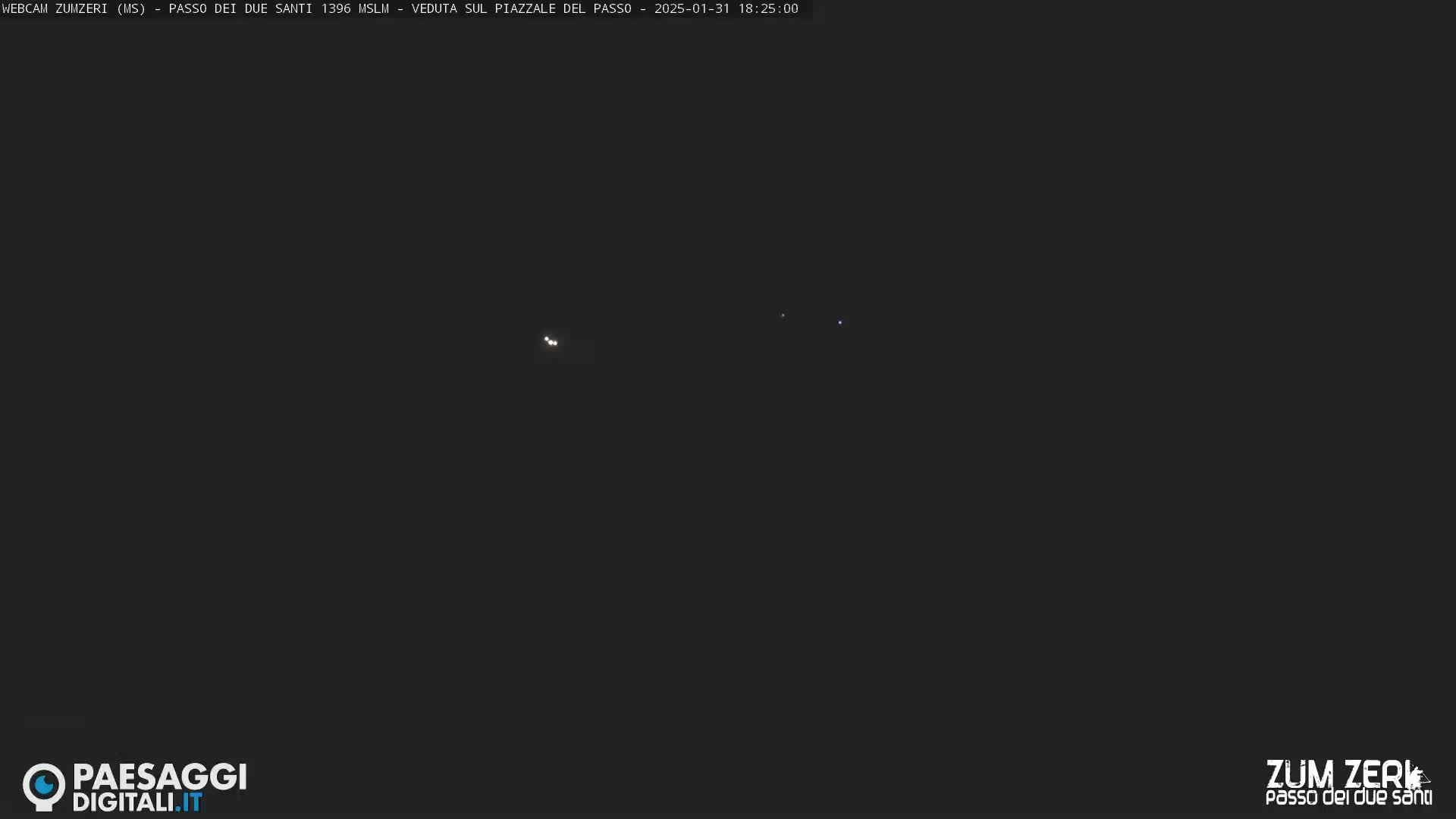 A dark nighttime scene shows several small, distant lights.
