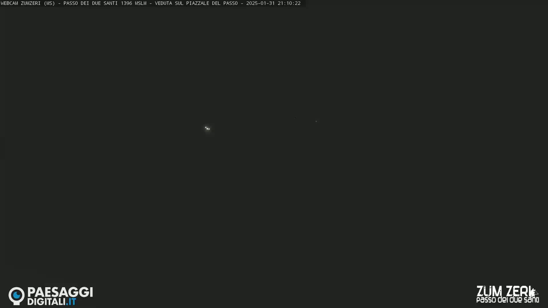 A dark, nighttime scene shows a few distant lights.
