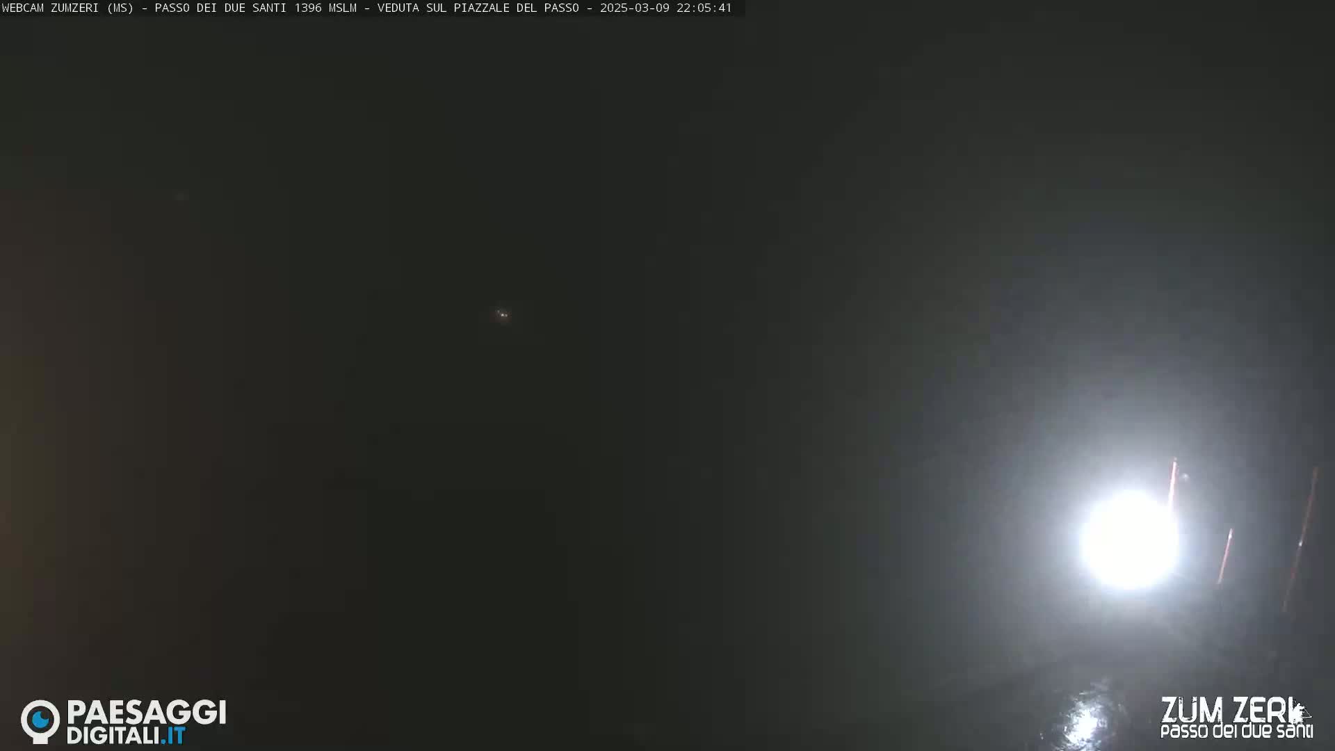 A nighttime, hazy scene is illuminated by a bright light source in the lower right corner.