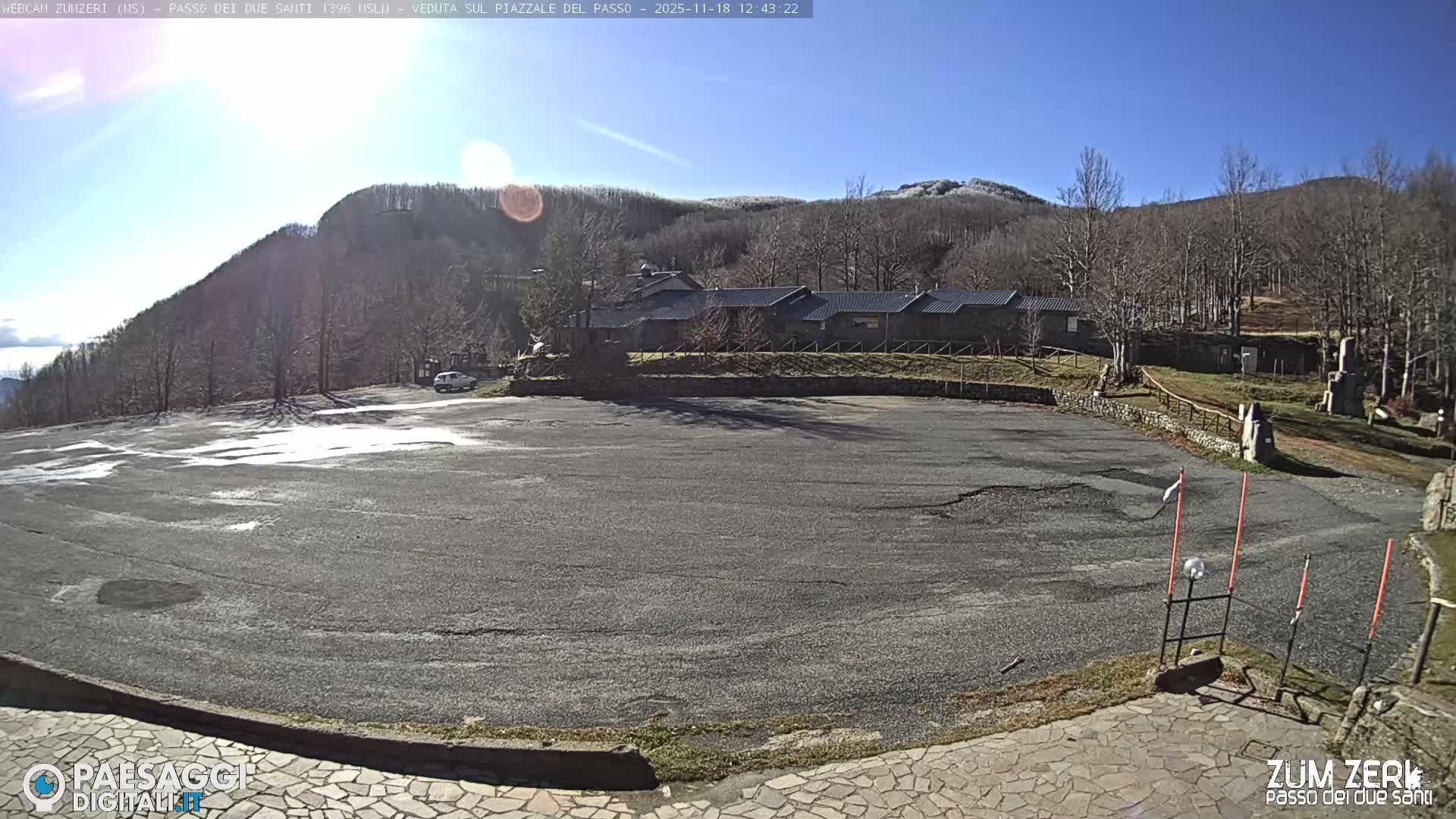 The image displays a dark, foggy night scene outdoors, illuminated by a bright, diffused light source in the lower right, with faint vertical markers visible on the right.