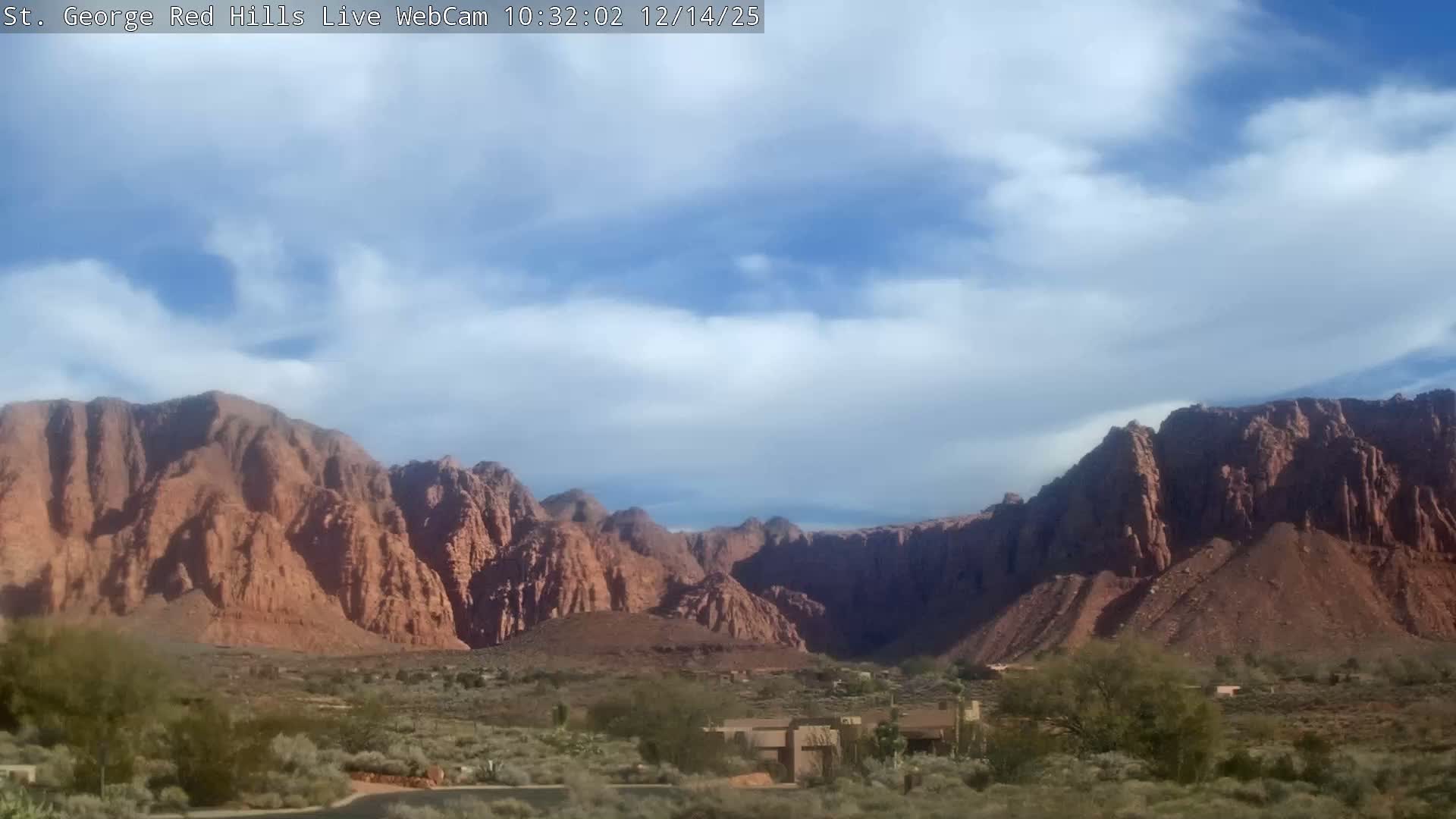 A dark and grainy nighttime landscape features rolling hills beneath a hazy or partly cloudy sky.