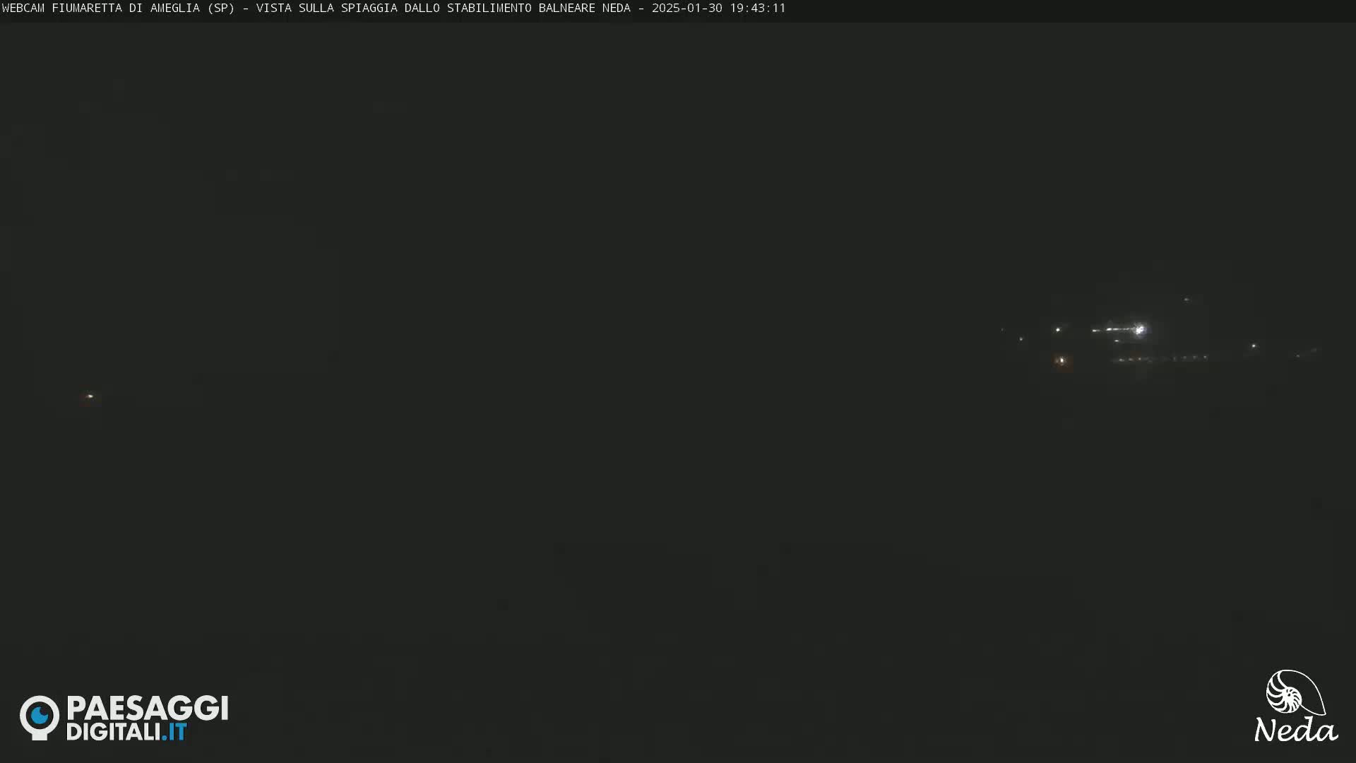 A dark nighttime scene shows faint lights in the distance.