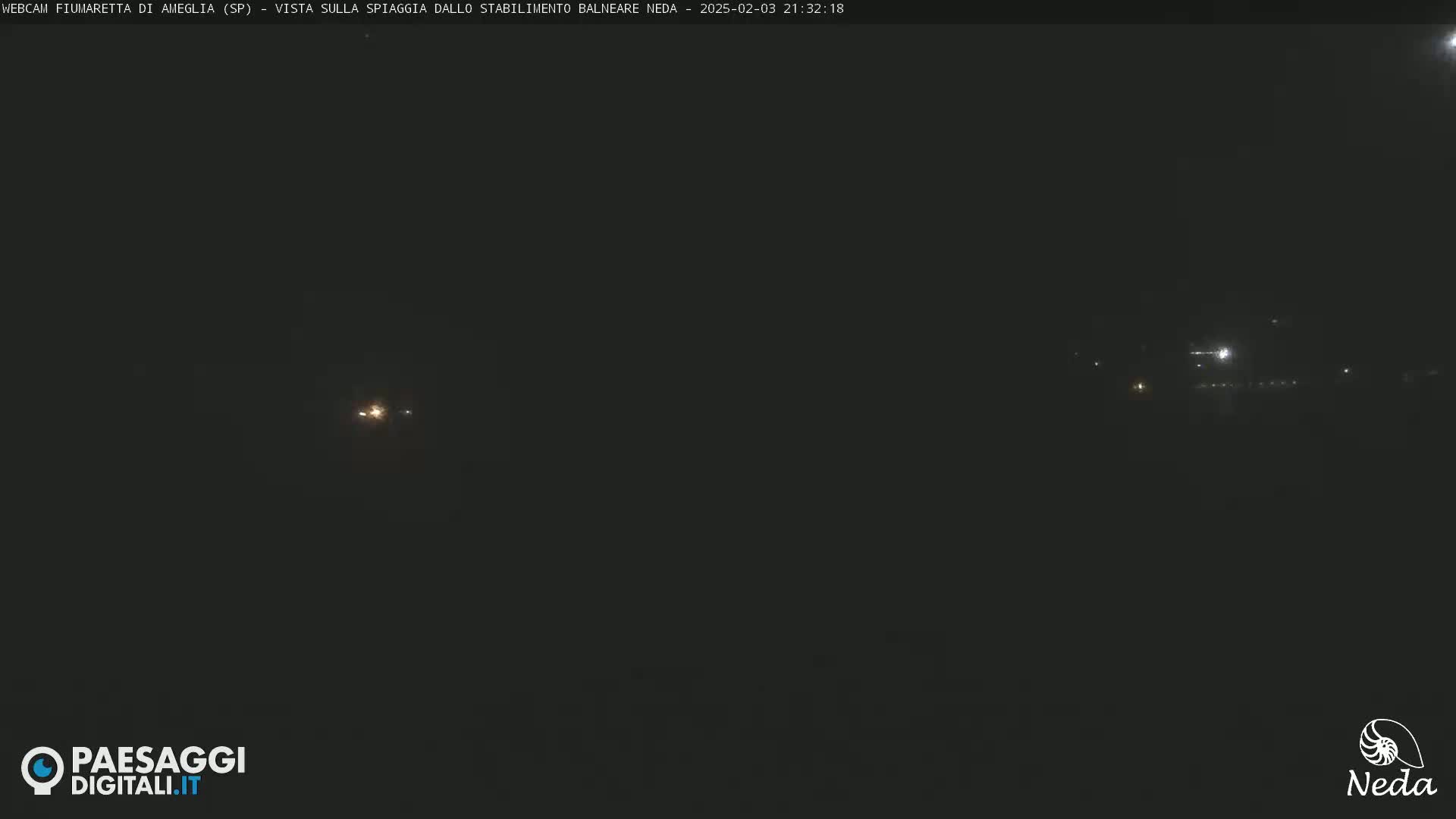 A dark, nighttime scene shows a few distant lights on the horizon.
