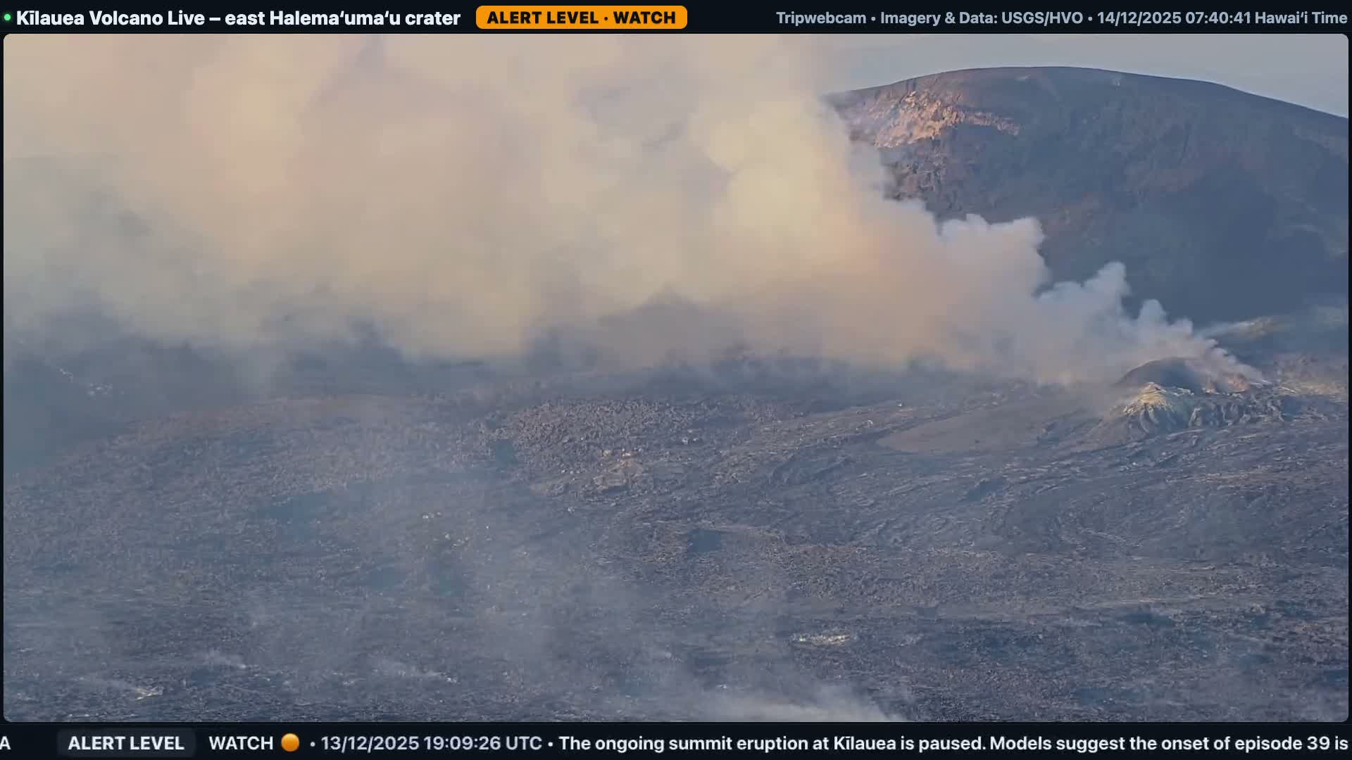 At night, a dark volcanic landscape is illuminated by brightly glowing areas on the left, with white and gray steam plumes rising and drifting across the terrain under clear sky conditions.