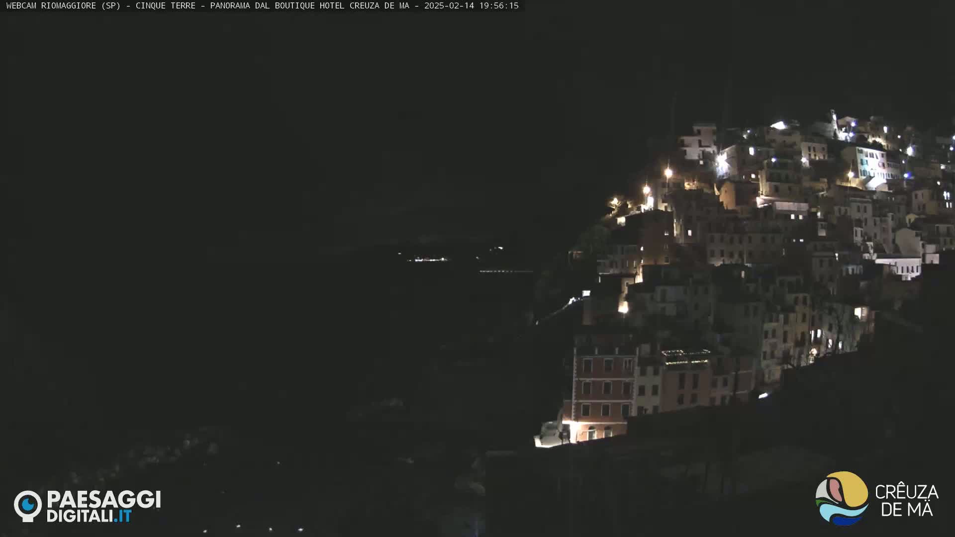 A hillside town is illuminated at night.