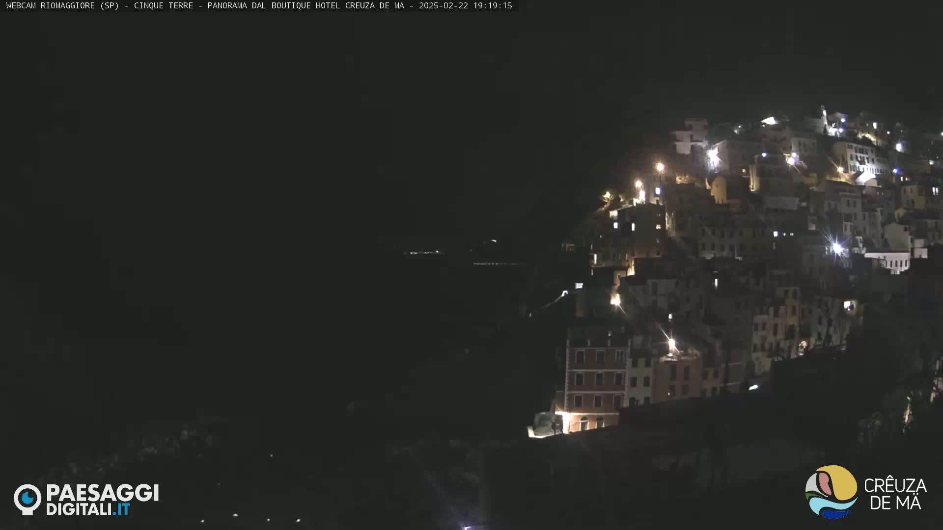 A hillside village is illuminated at night.