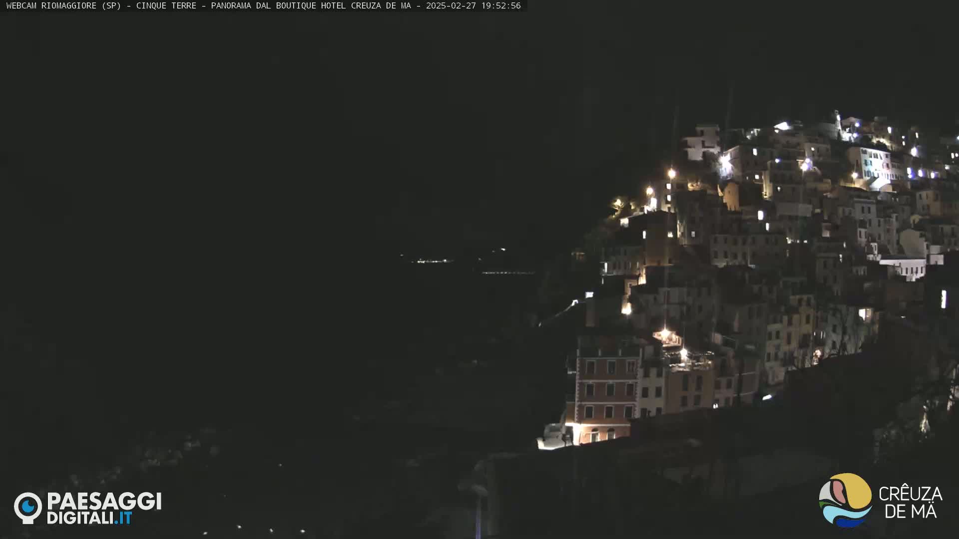 A hillside town is illuminated at night.