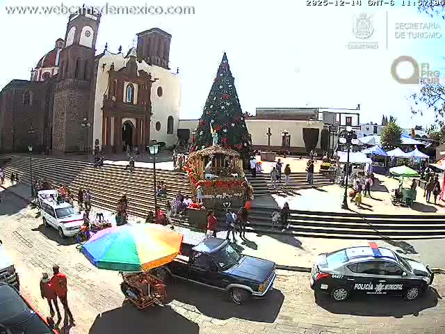A police pickup truck with flashing blue and red lights is parked on a dark street at night, with a brightly illuminated historic church and steps in the background under clear weather conditions.