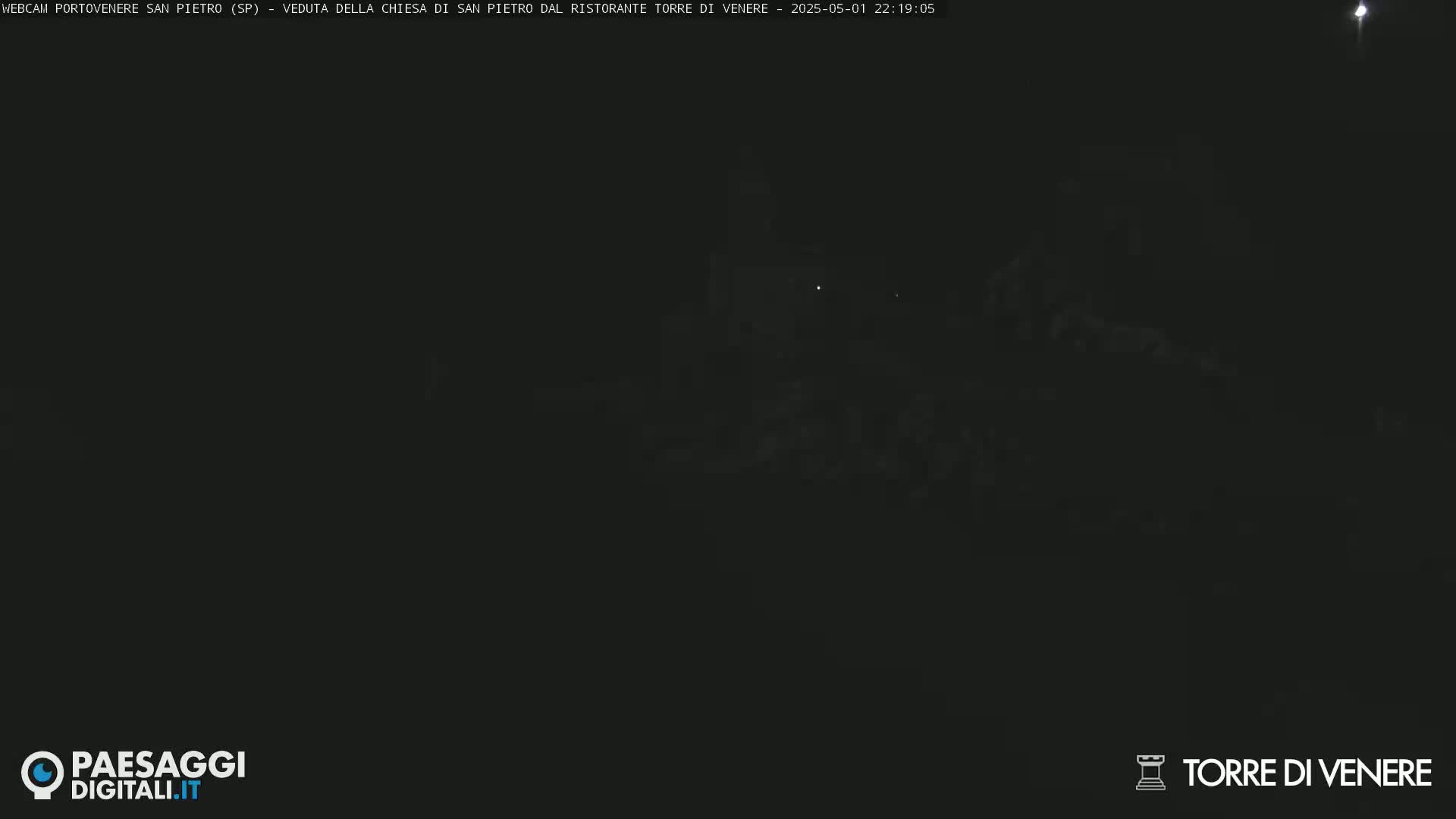 A very dark, nighttime image shows a dimly lit, indistinct scene.