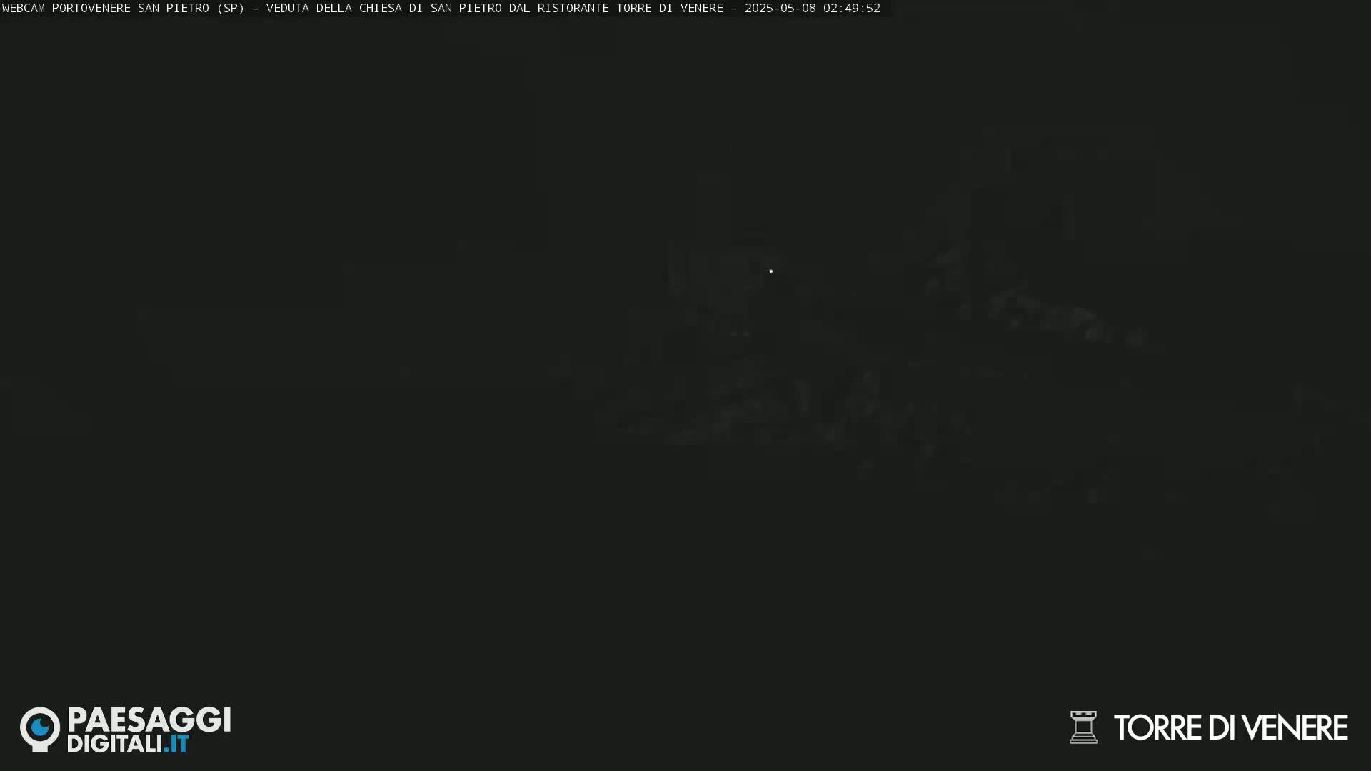 A very dark, nighttime image shows indistinct shapes and faint lights.
