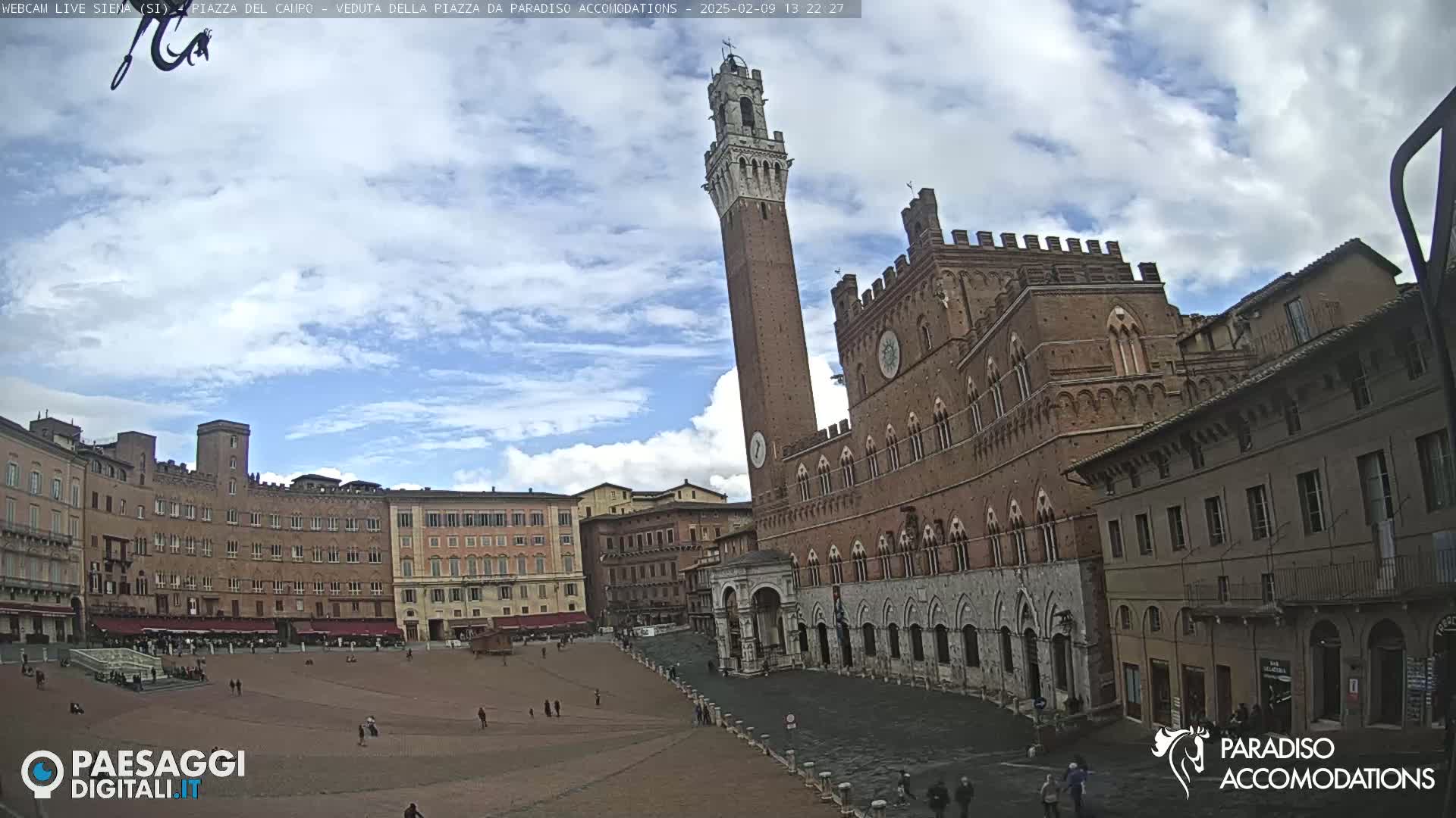A large, brick piazza in Siena, Italy, is under a partly cloudy sky.