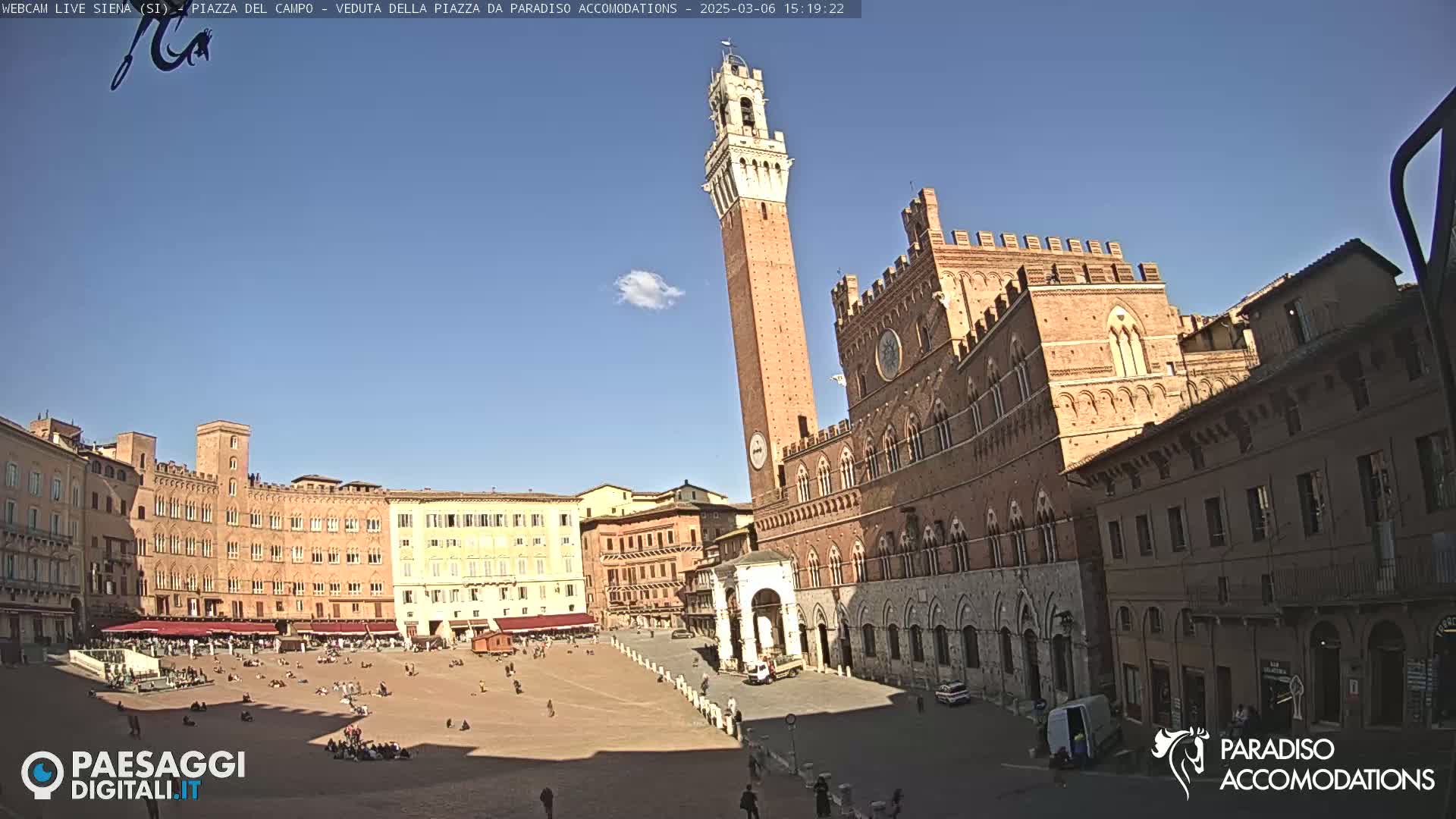 A large, mostly empty piazza in Siena, Italy, is surrounded by medieval buildings under a clear blue sky.
