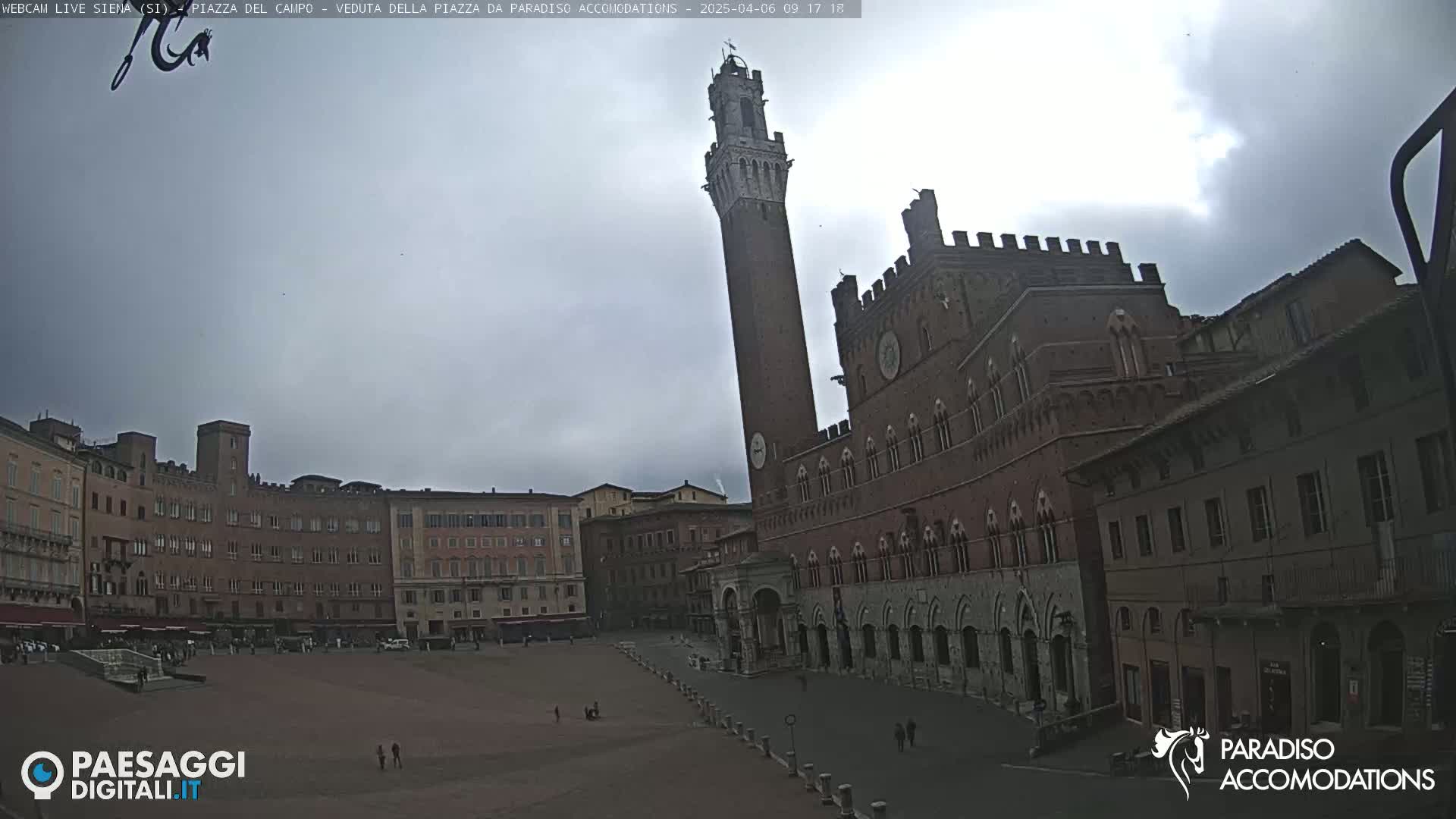 A large, empty piazza in Siena, Italy, is shown under an overcast sky, with the Palazzo Pubblico and Torre del Mangia prominently featured.