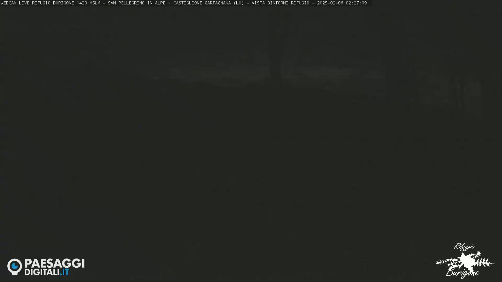 A dark, nighttime image shows an indistinct, blurry view of an outdoor scene.