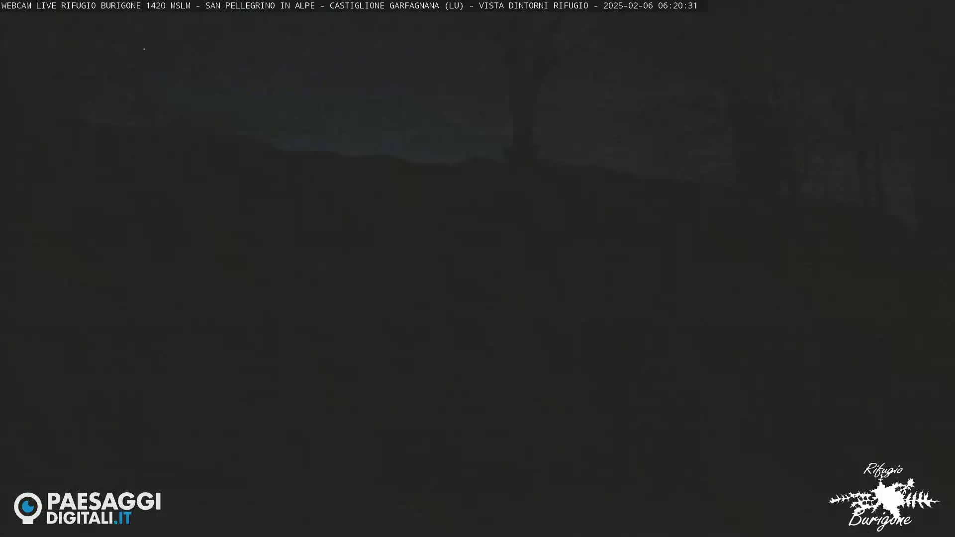 A dark, nighttime outdoor scene shows a mostly indistinct landscape under a mostly clear sky.