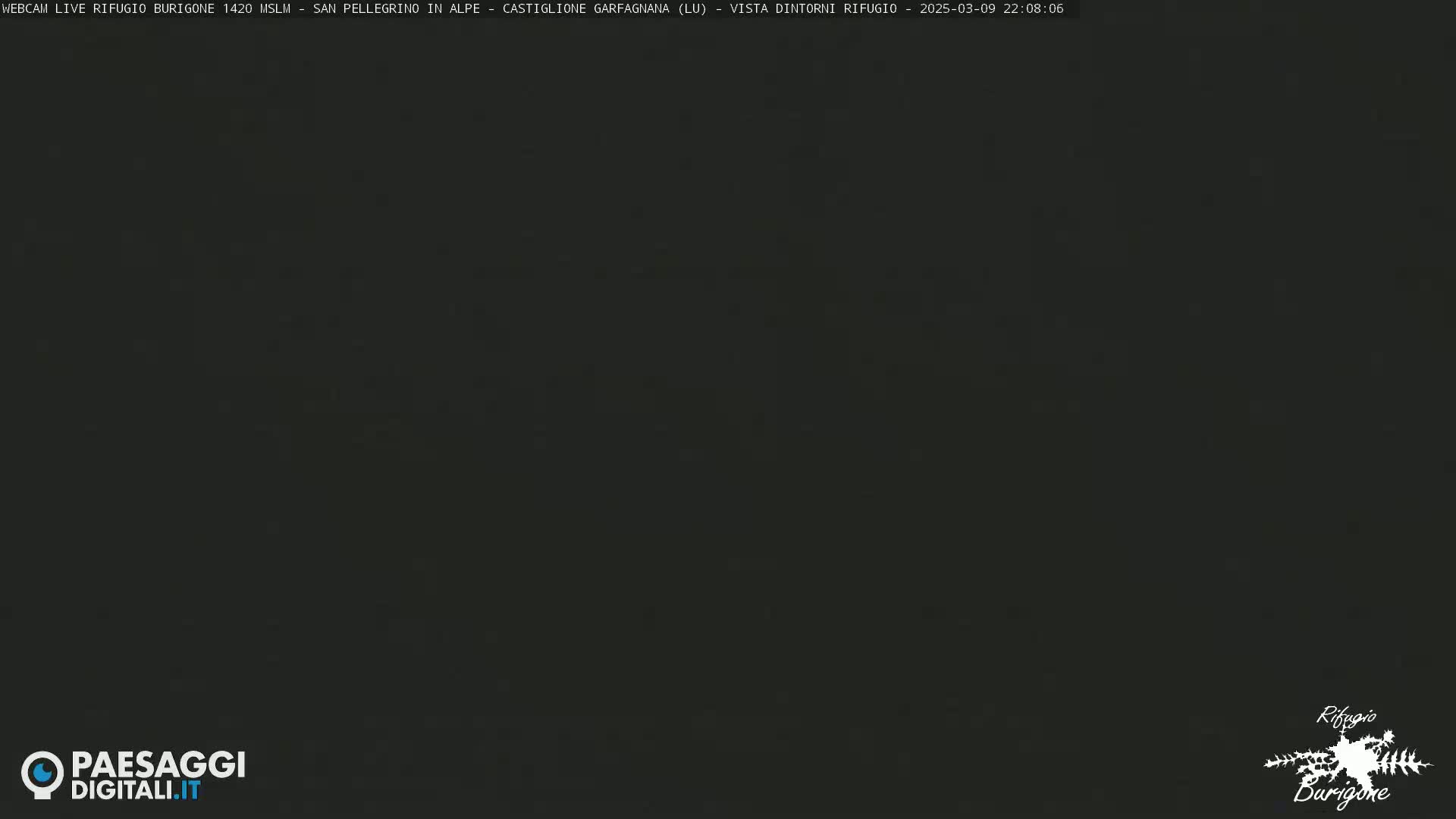 A dark, nighttime image shows a mostly black screen with a faint suggestion of a landscape in the distance.
