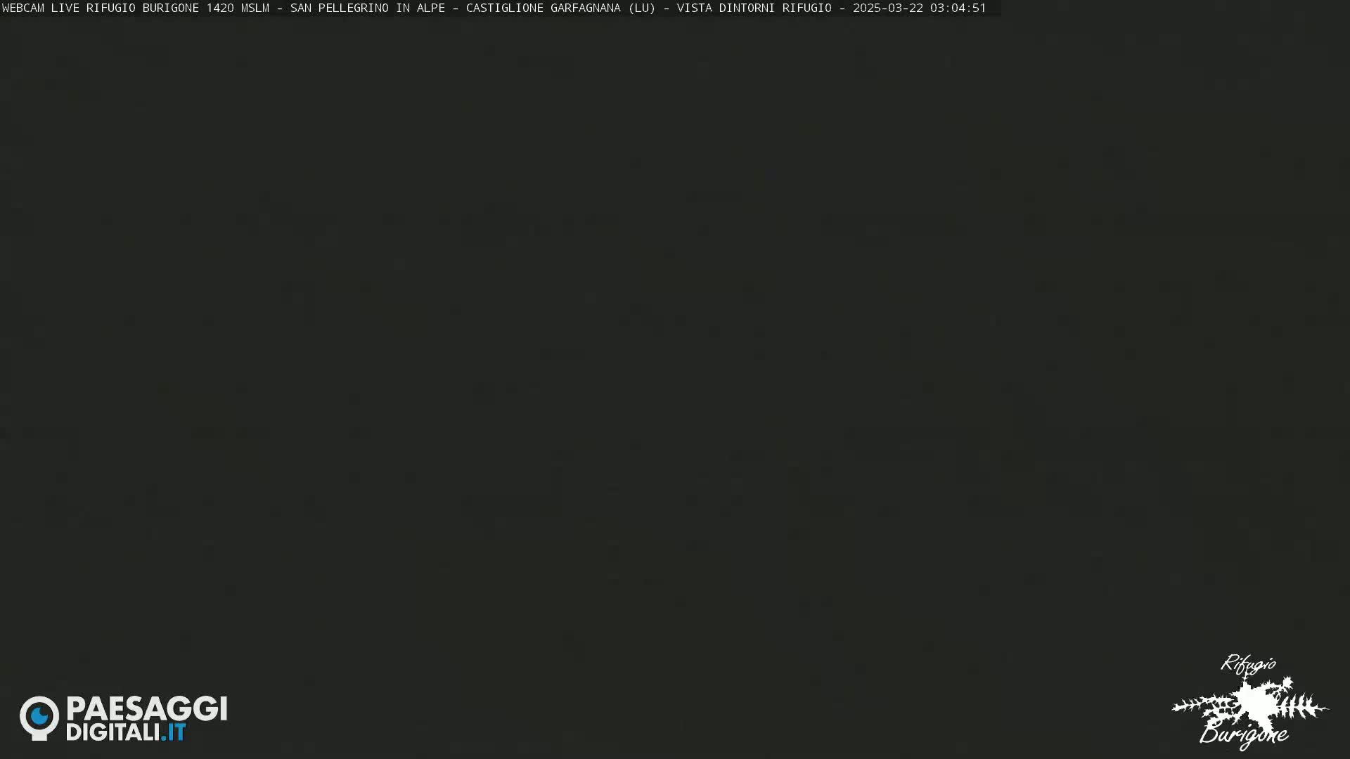 A dark, nighttime image shows a mostly black sky with a few faint specks of light.