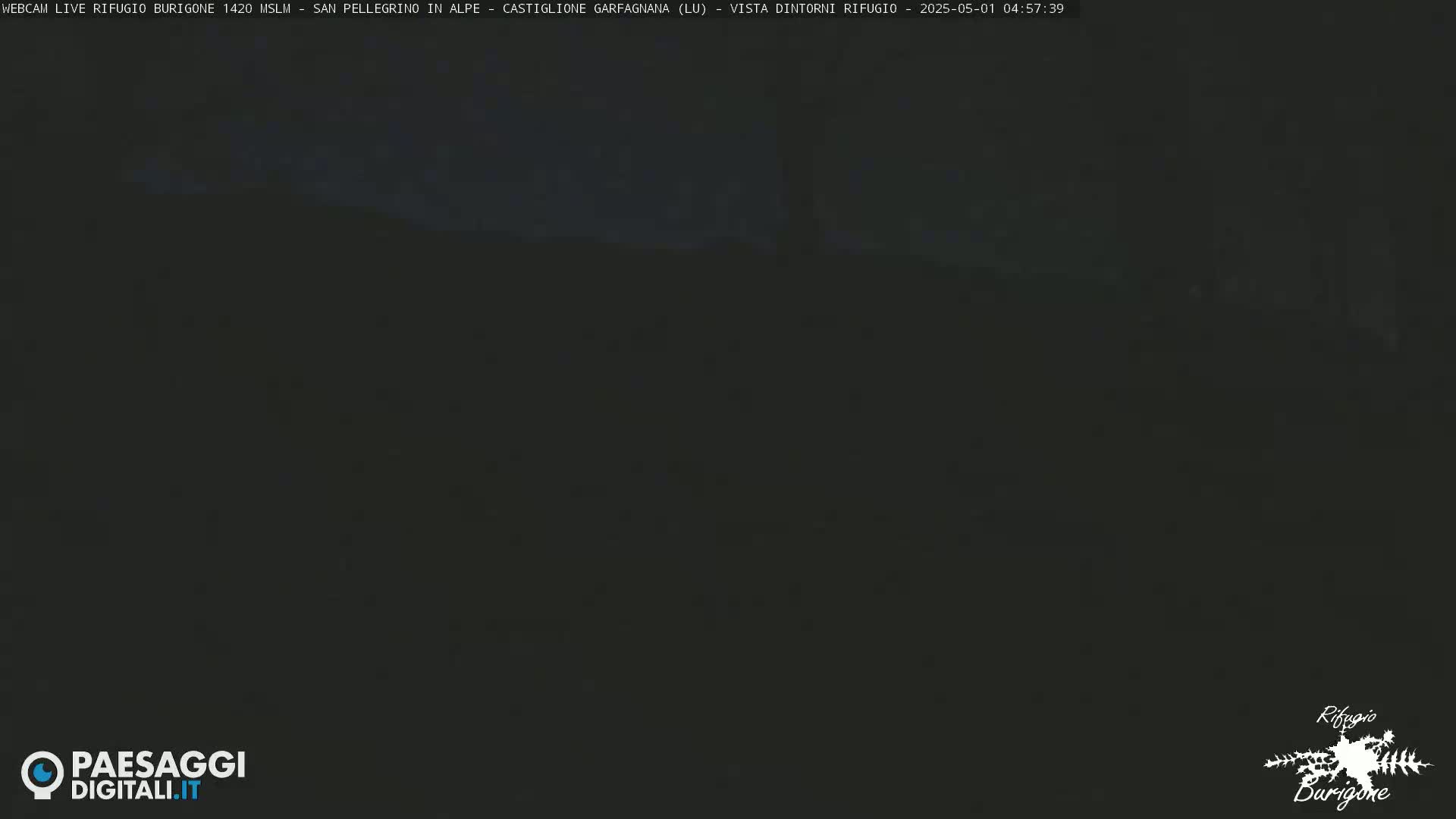 A dark, nighttime view of a mostly obscured landscape.