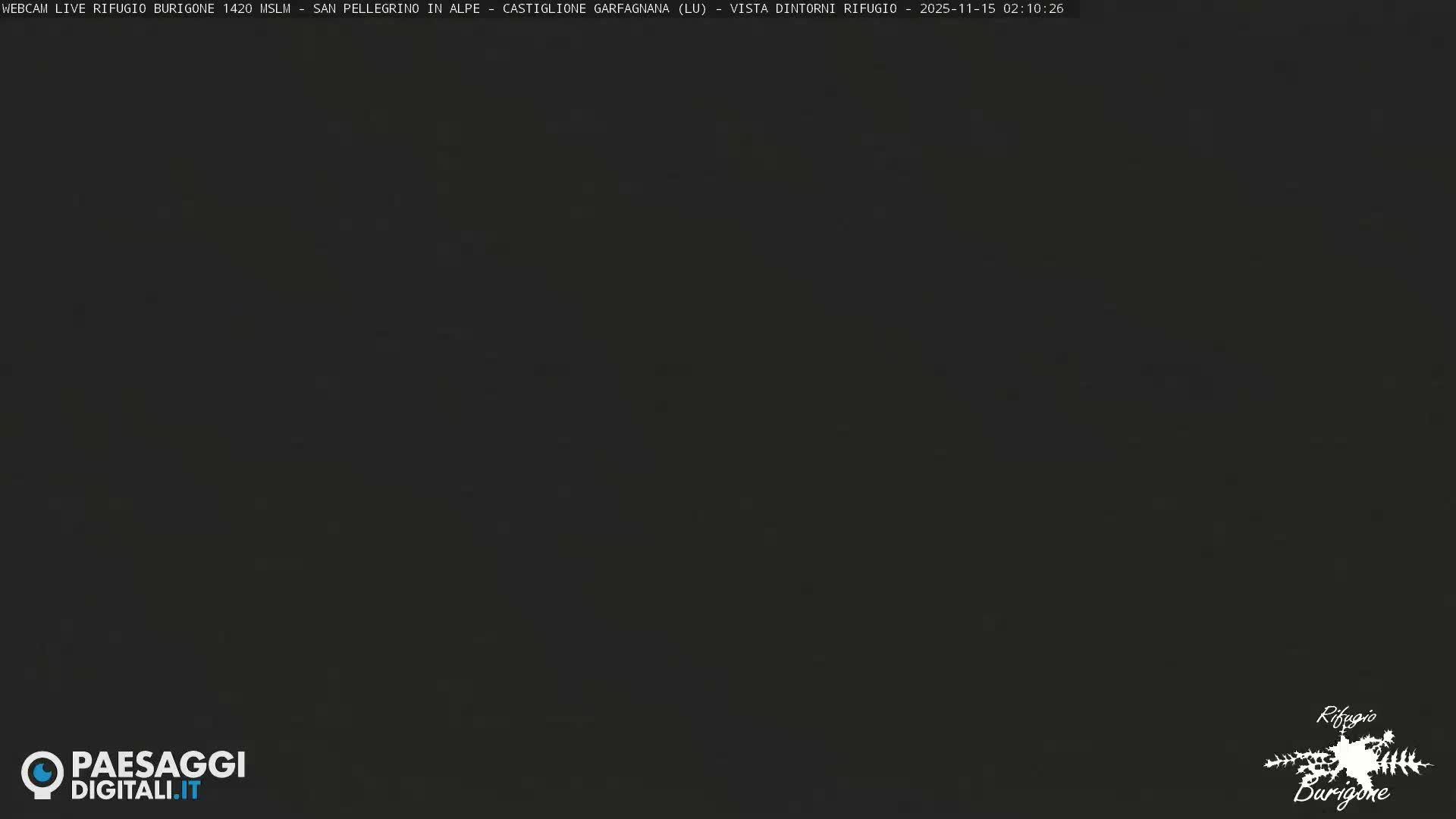 The image displays a dark, almost entirely black scene with very faint, sparse white specks scattered across it, indicating a clear night.