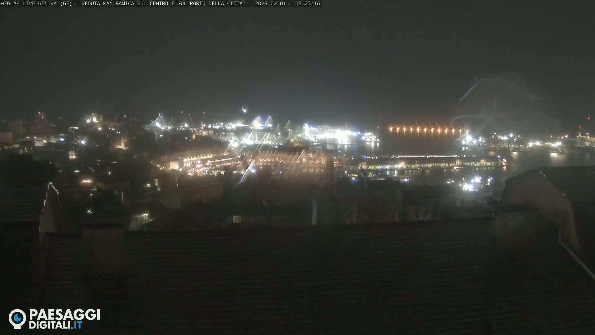 A nighttime, hazy view of a city's harbor and city lights, partially obscured by what appears to be rain or fog.