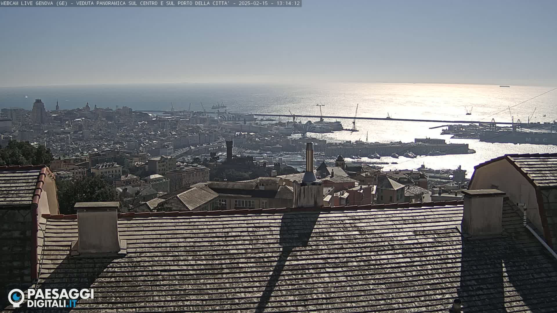 A sunny day reveals a panoramic view of a city harbor and buildings extending to the sea.