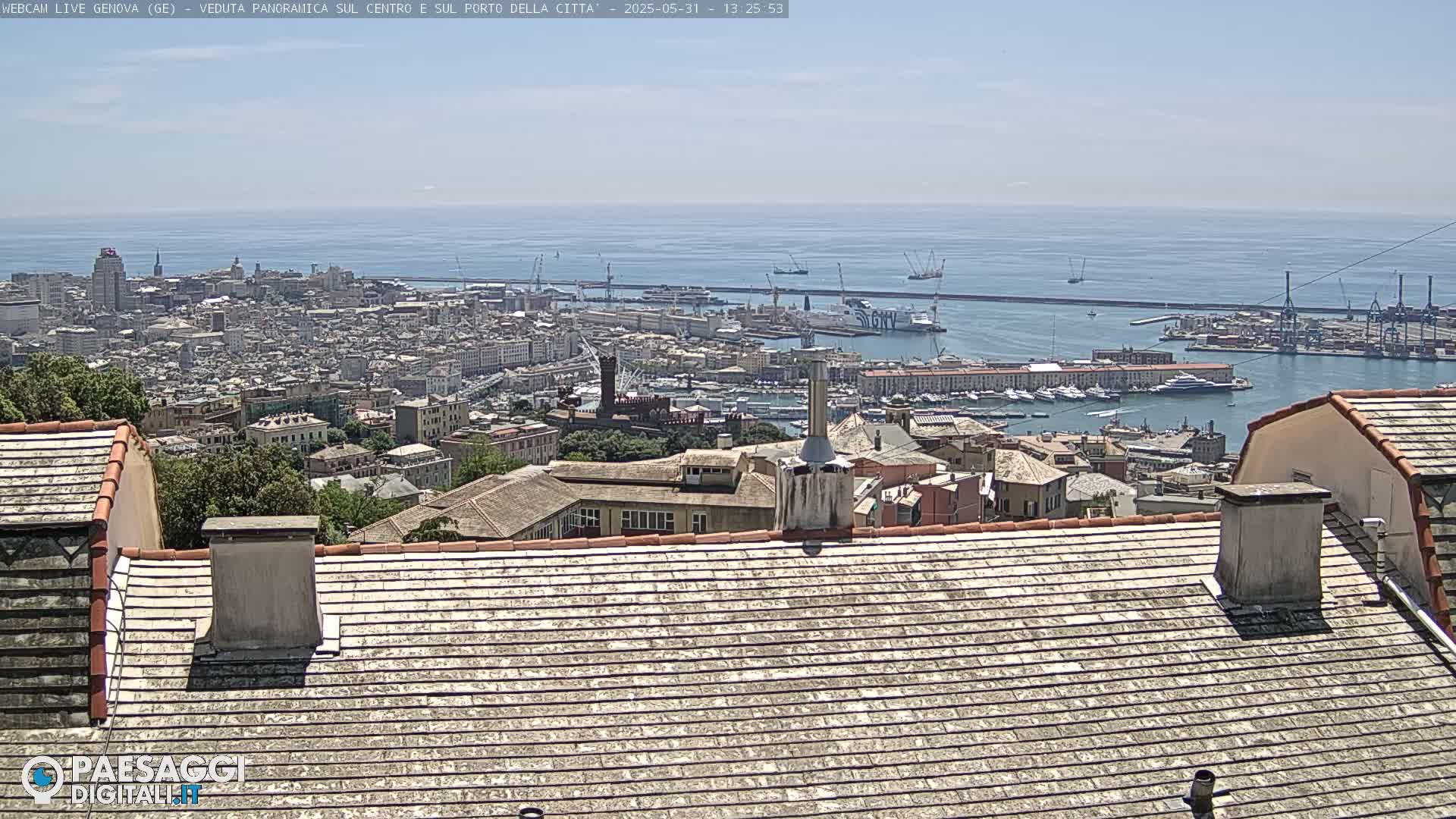 A panoramic view of a city and harbor on a sunny day, seen from a rooftop with weathered tiles.