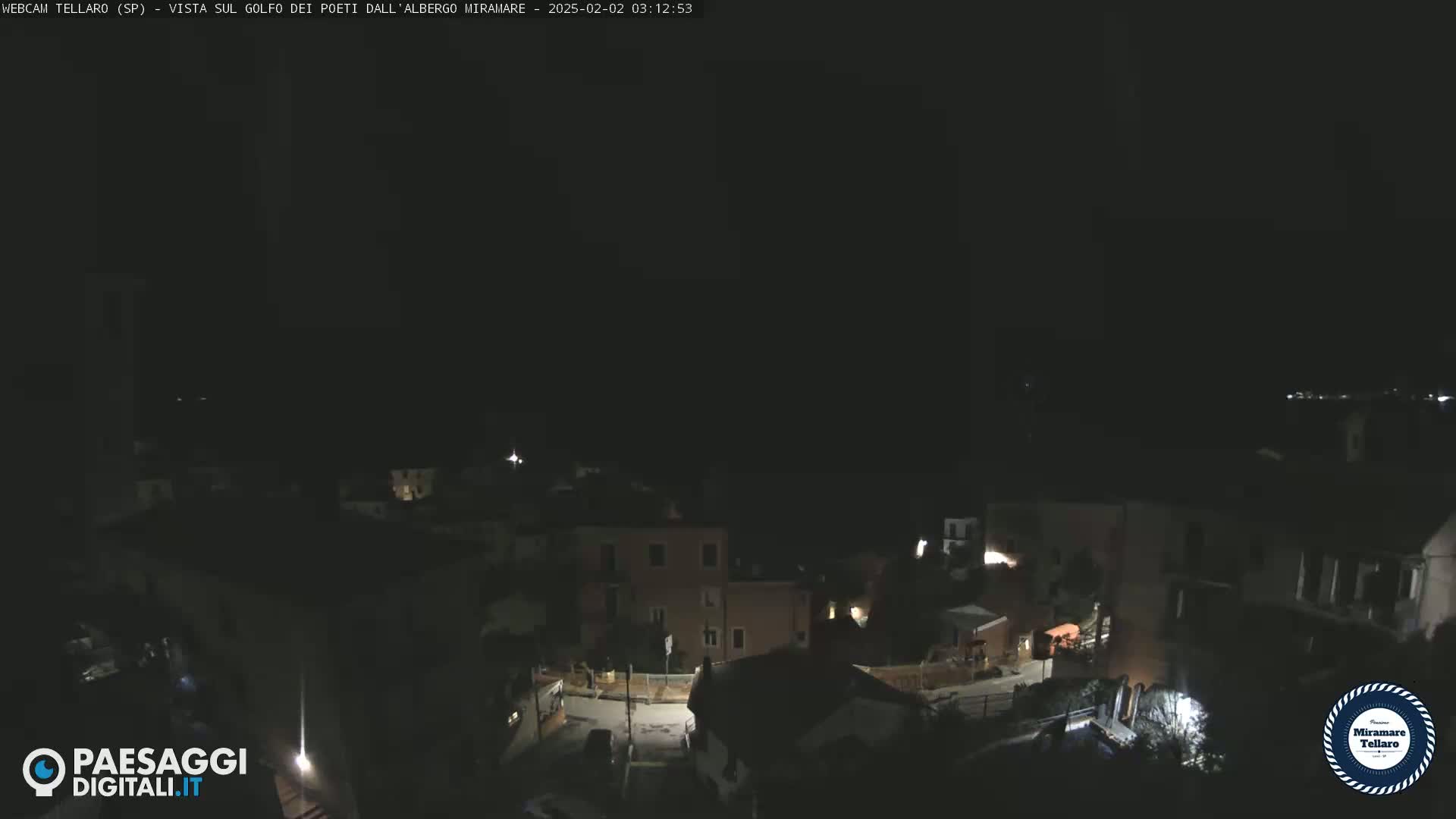 A nighttime, dark view of a small town with dimly lit buildings and streets.