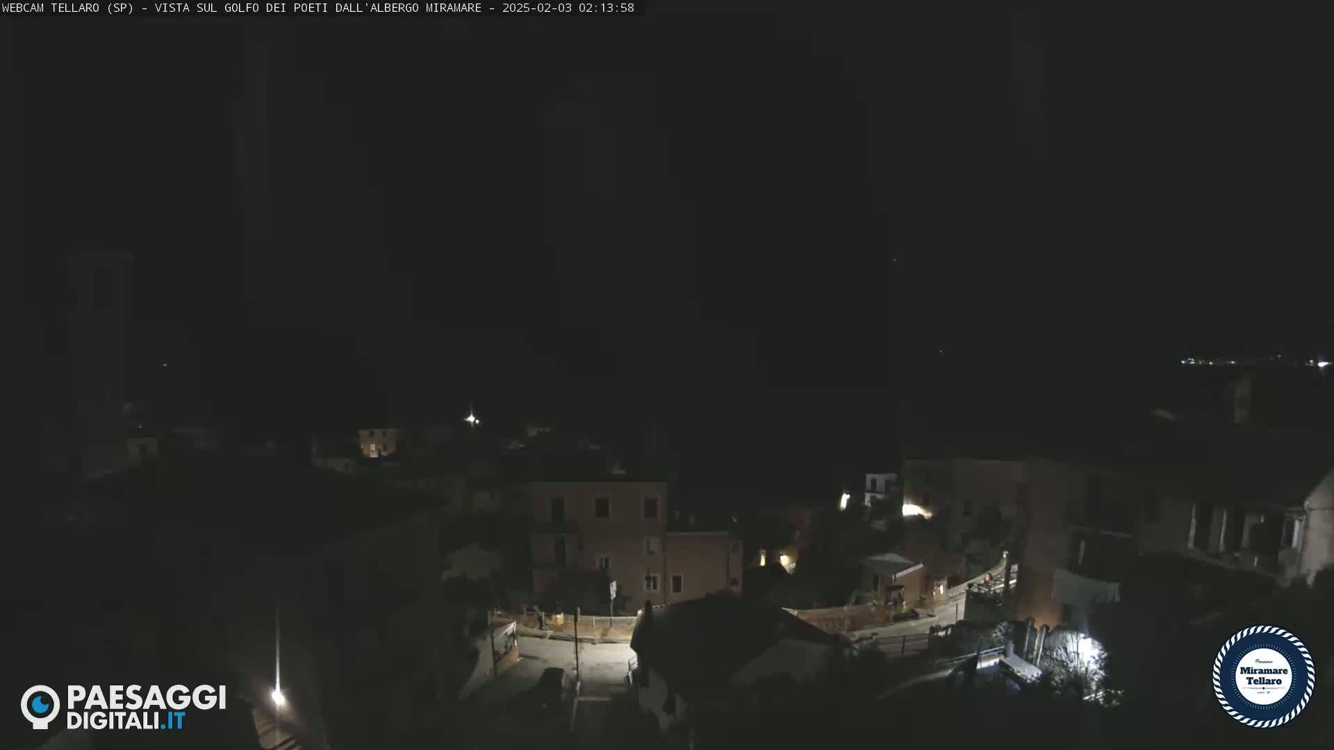 A nighttime, dark view of a town with sparsely lit buildings and streets.