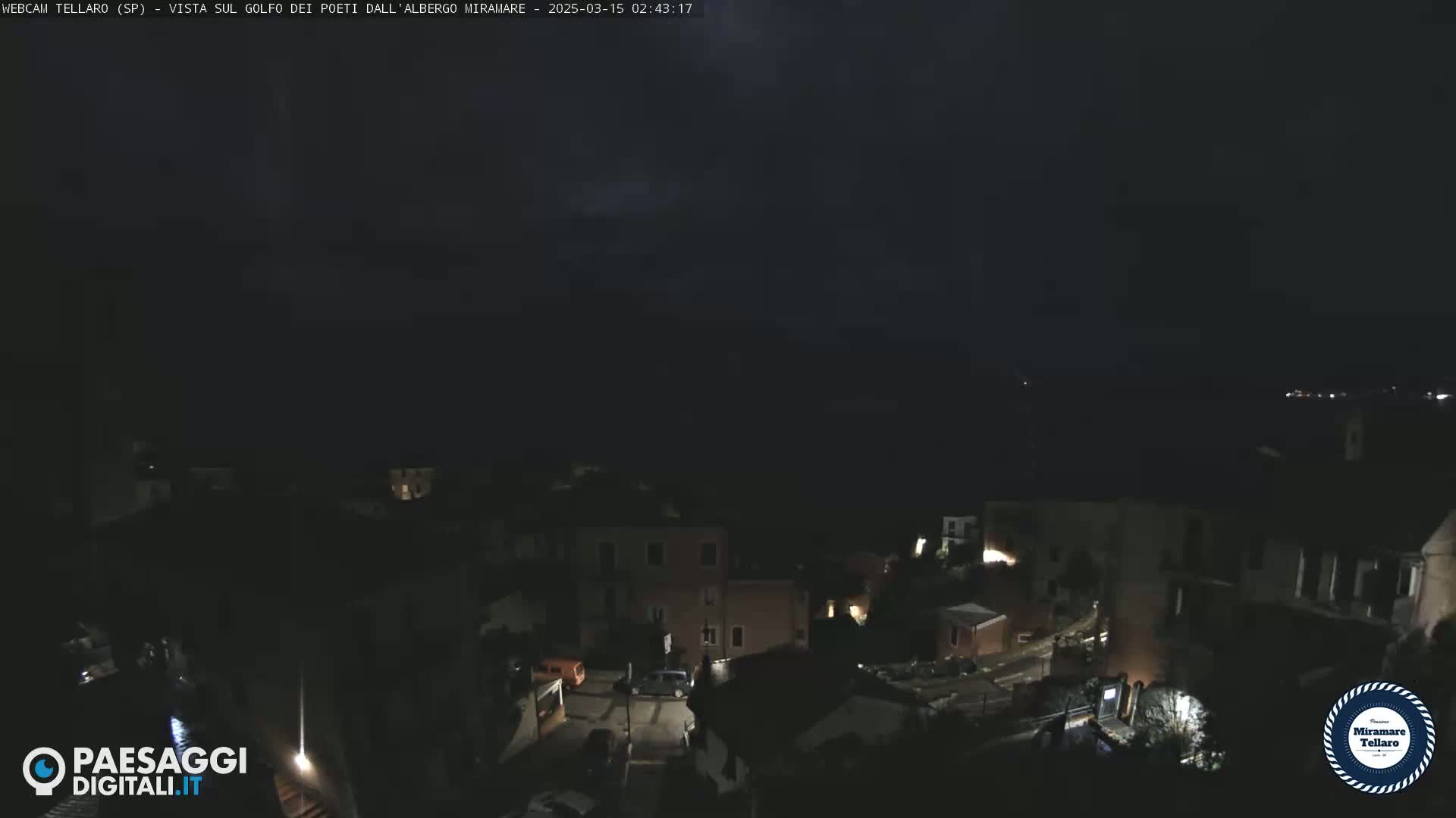 A nighttime, possibly stormy, view of a small town with dimly lit buildings and streets.