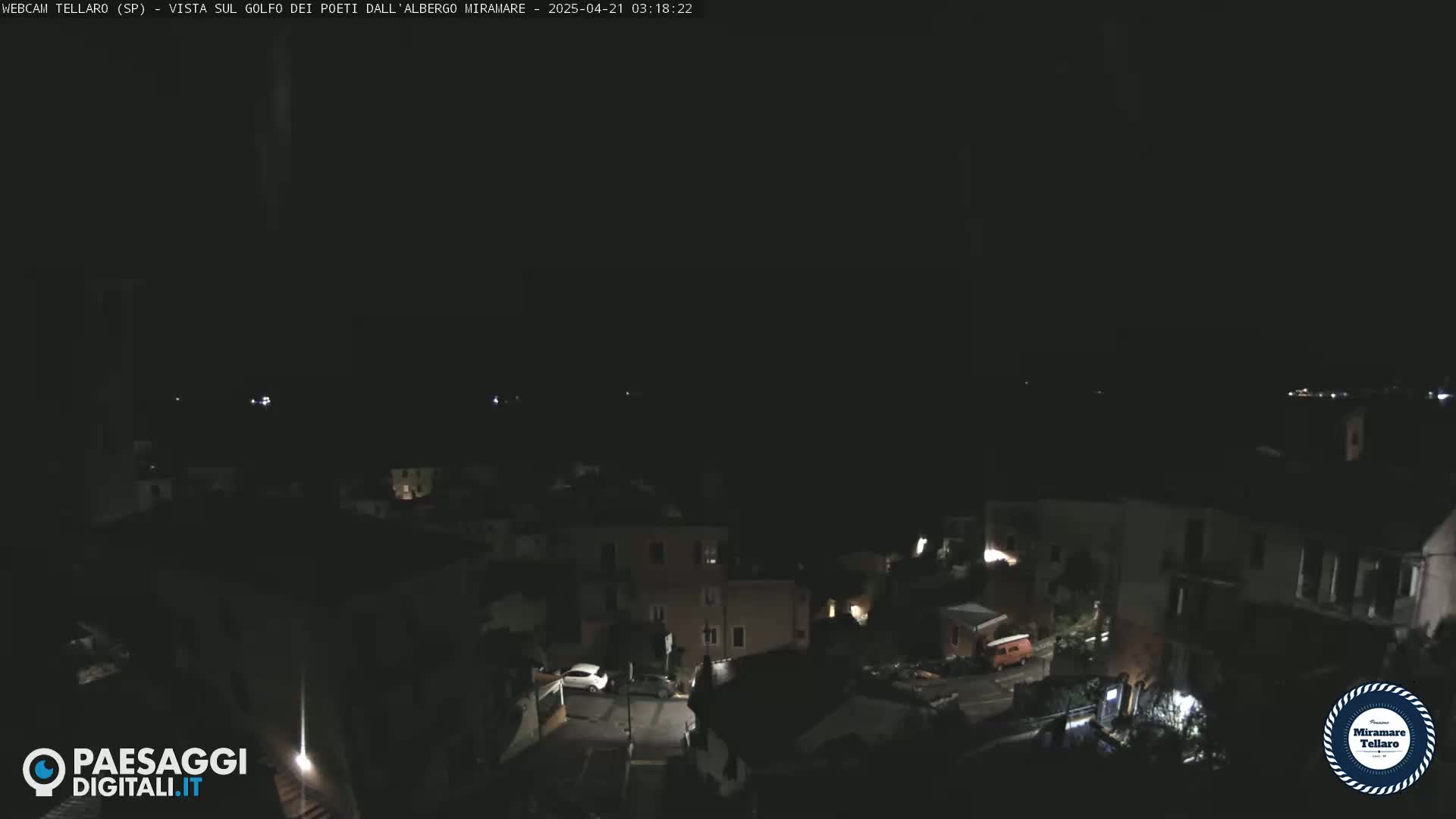 A dark nighttime view of a town, showing dimly lit buildings and streets.