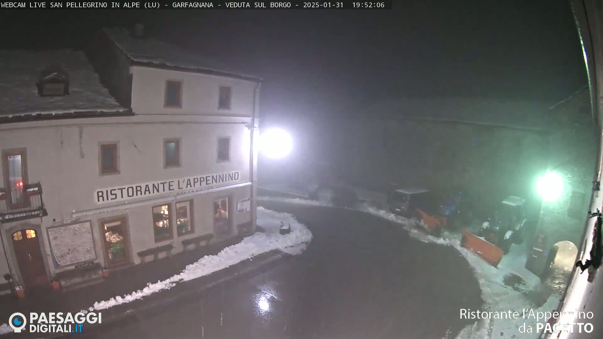 A snow-covered restaurant called "Ristorante l'Appennino" is visible at night, with some snow removal vehicles nearby in foggy conditions.