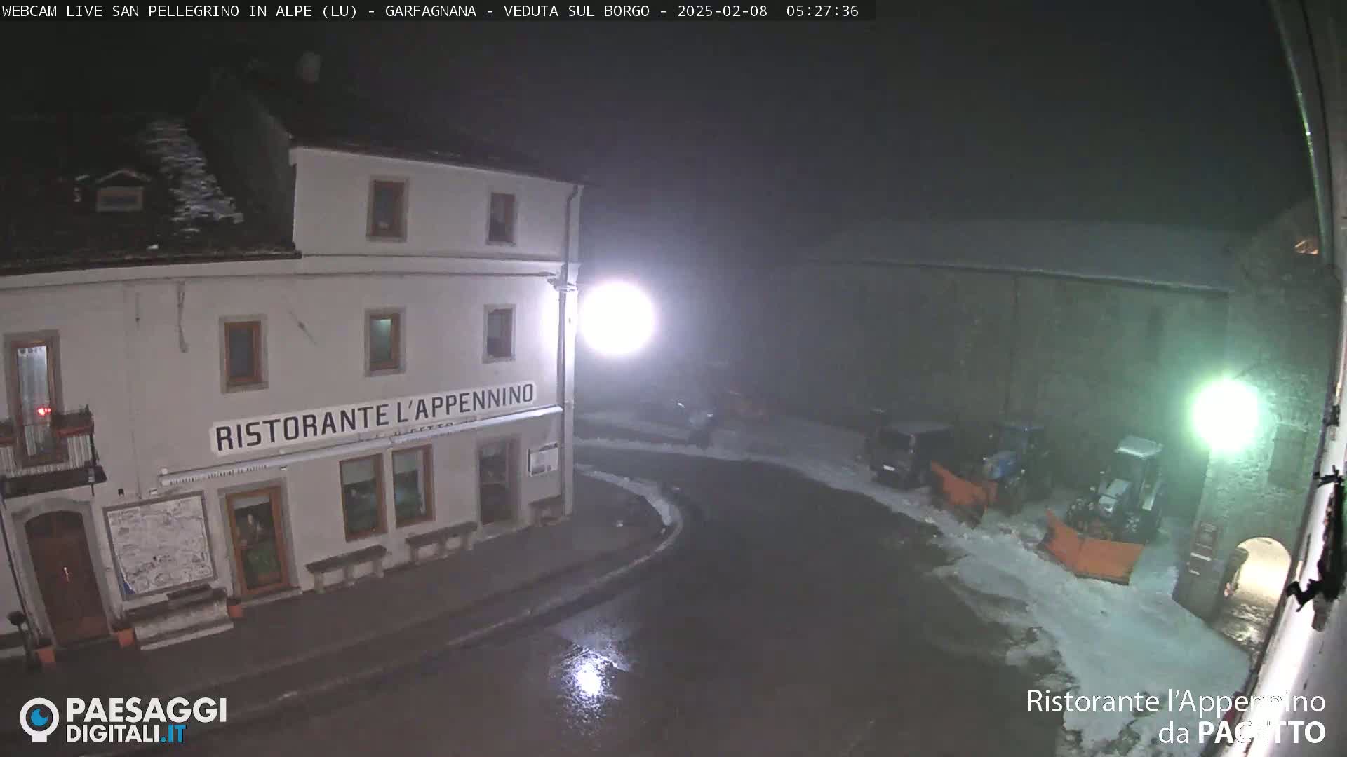A nighttime, snowy scene shows a restaurant called "Ristorante L'Appennino" with snow plows parked nearby.