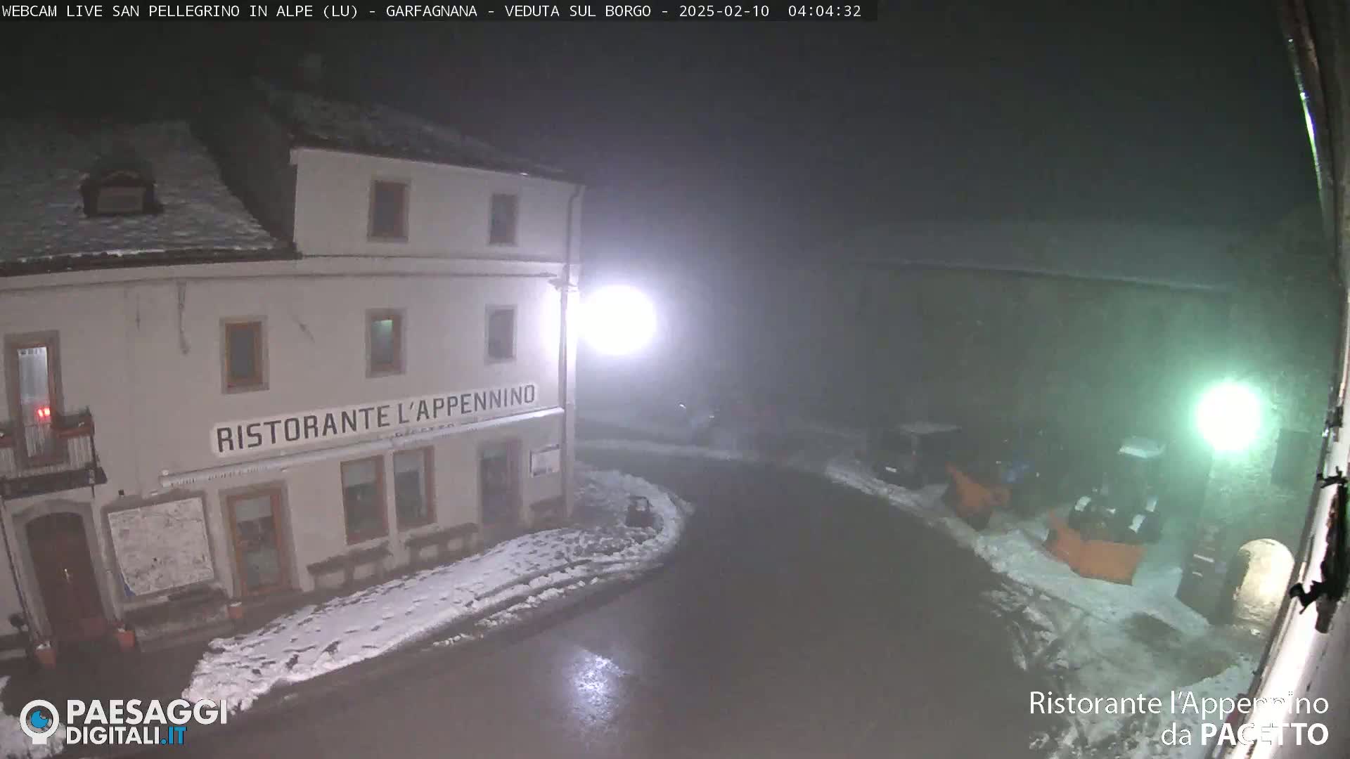 A nighttime, snowy scene shows a restaurant called "Ristorante l'Appennino" with several vehicles parked nearby in foggy conditions.