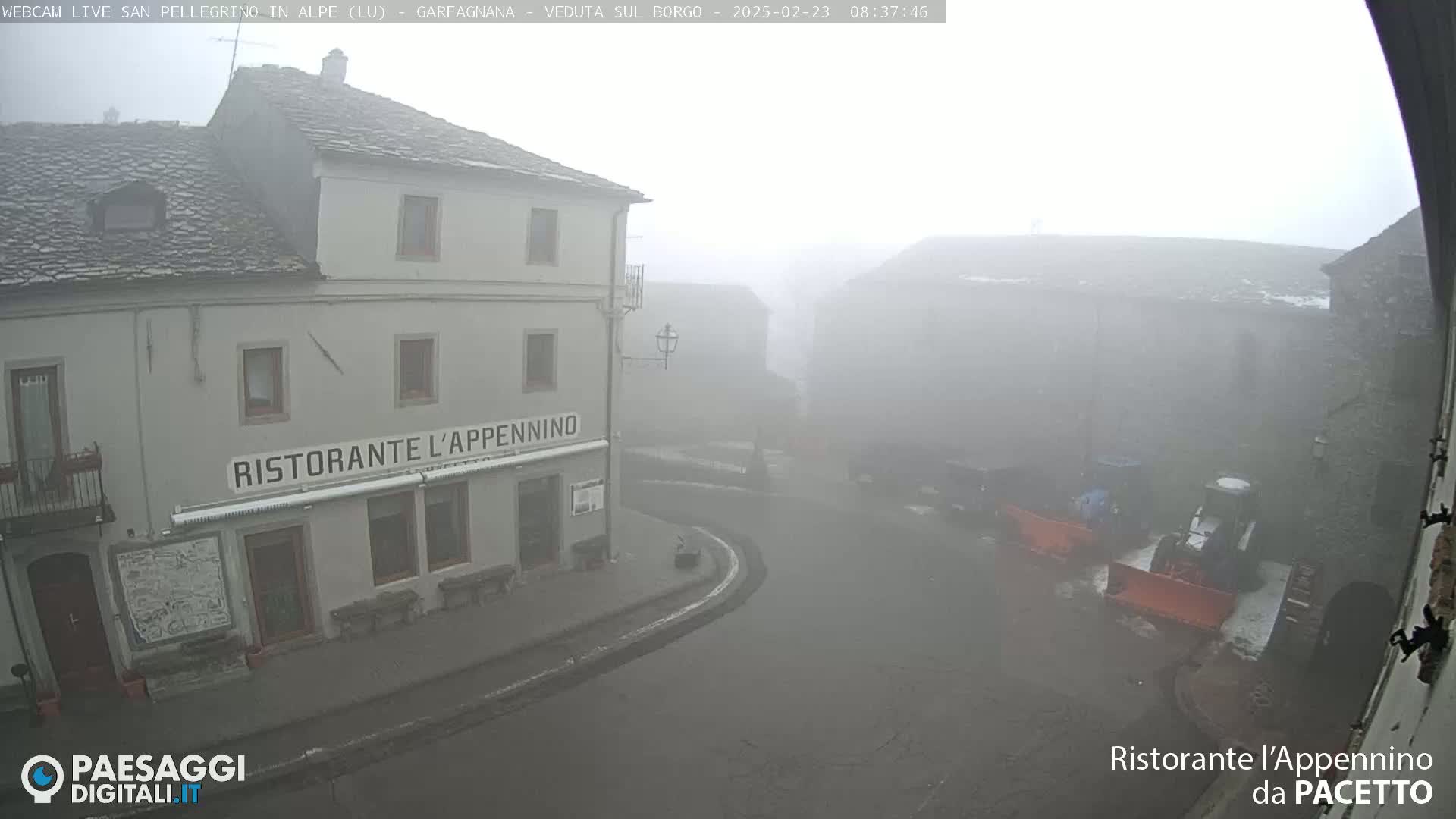 A foggy village scene shows a restaurant and several buildings, with snow plows visible in the street.