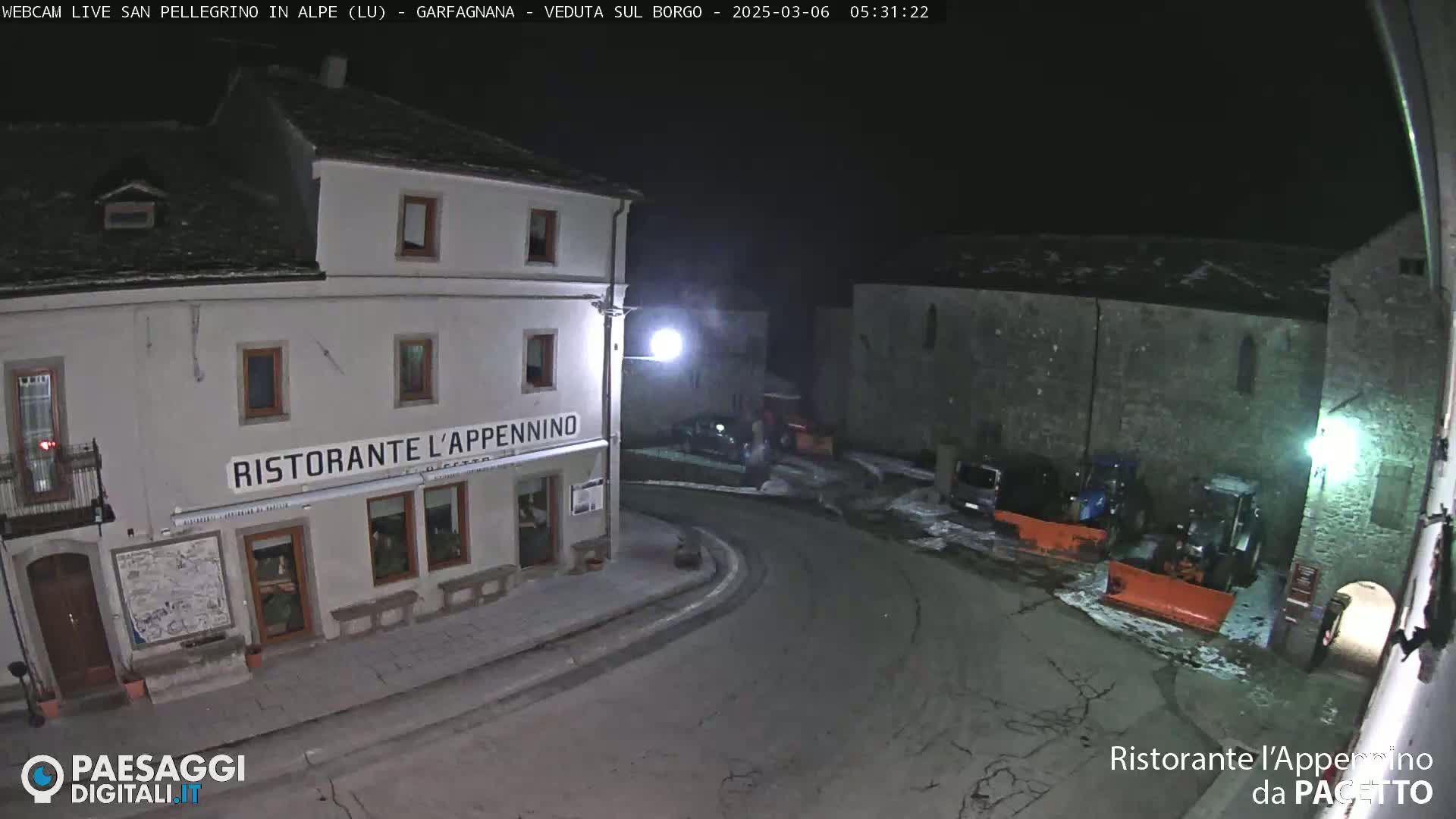 A nighttime, snow-covered street scene shows a restaurant called "Ristorante L'Appennino," parked vehicles, and snow-removal equipment.