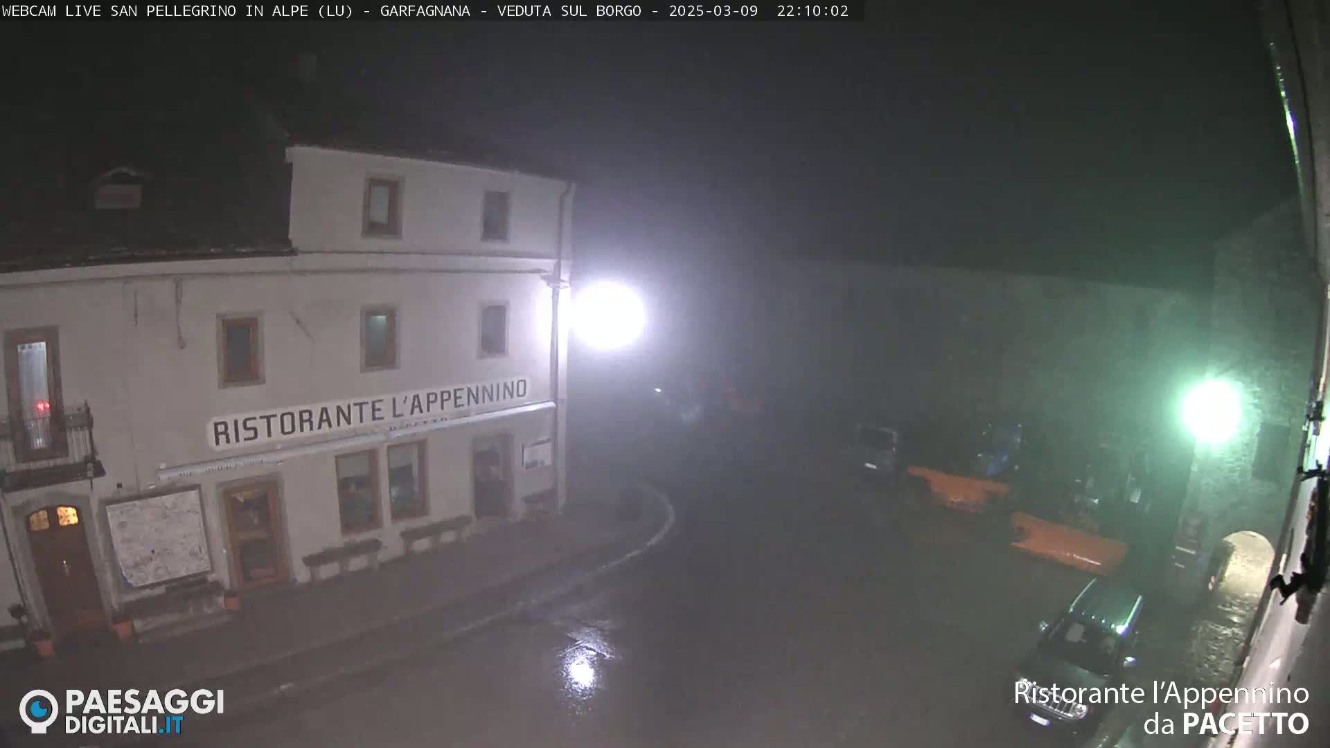 A nighttime, rainy view of a restaurant called "Ristorante l'Appennino" with several cars parked nearby.