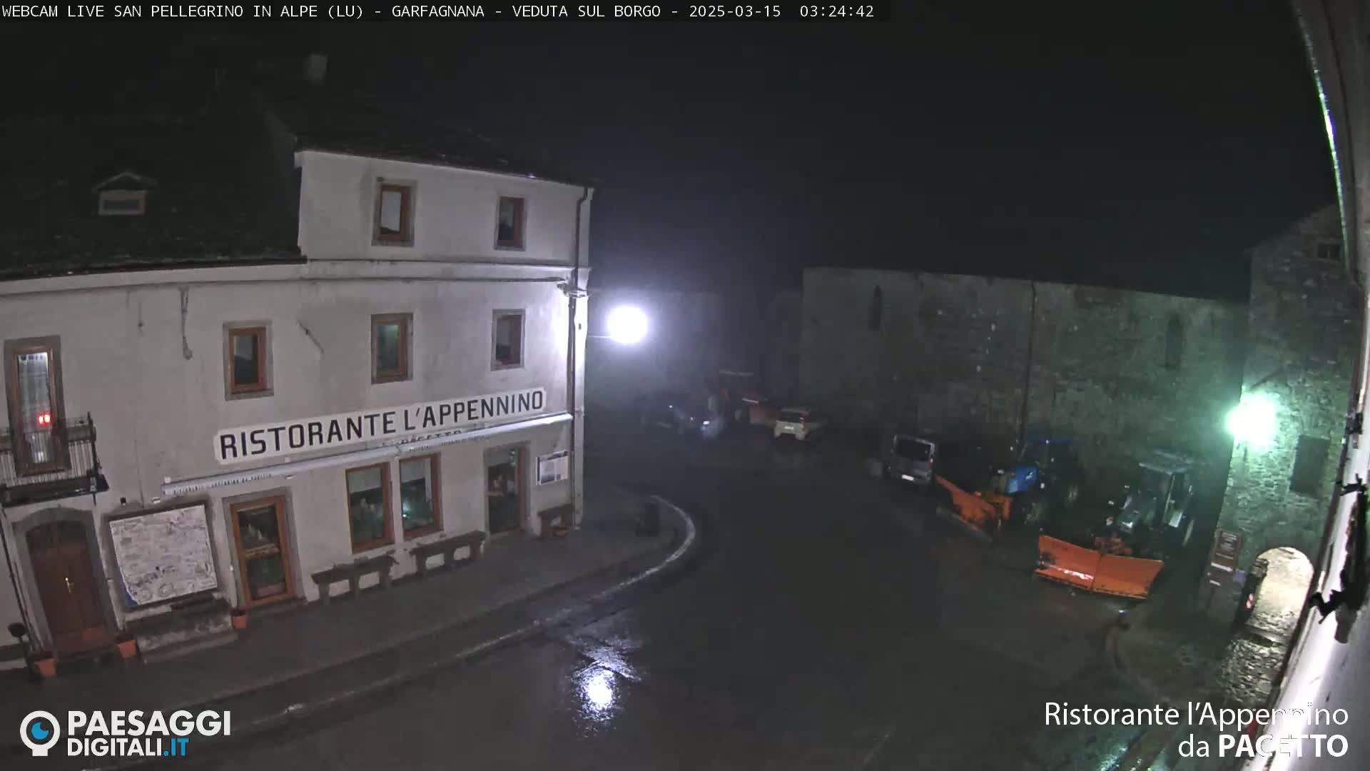 A nighttime, wet street scene shows a restaurant called "Ristorante l'Appennino," some parked cars, and snowplows.