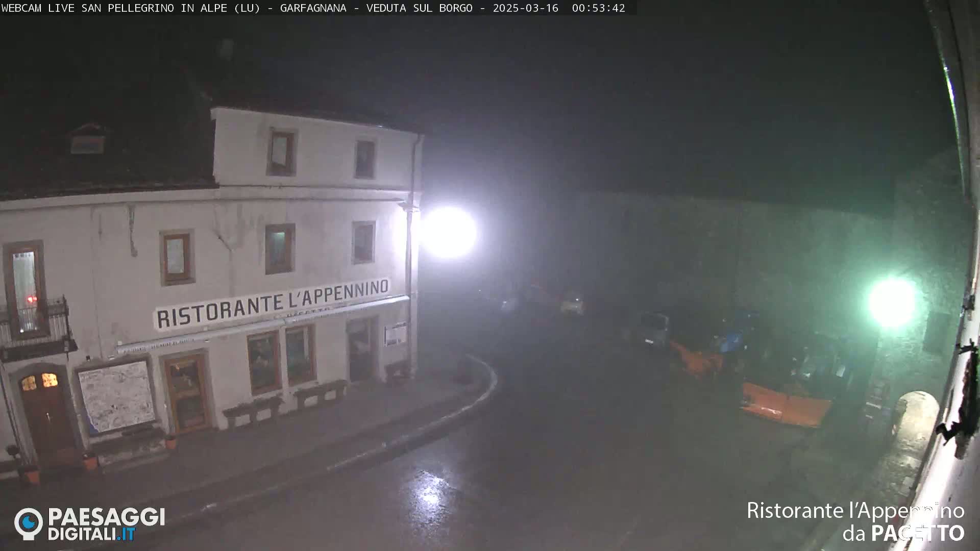 A nighttime view of a restaurant called "Ristorante L'Appennino" in the rain, with several vehicles parked nearby.